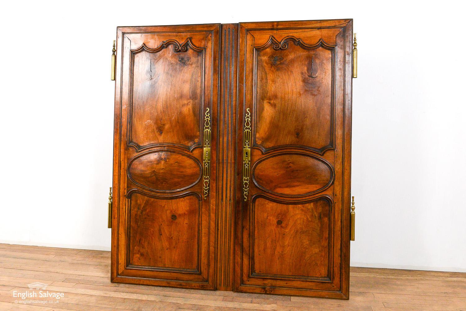 Antique pair of French chestnut cupboard double doors with quality original brass door furniture. Good condition overall with a small crack to the top panel of the right hand door. One door measures 10cm wider as it has the fluted centre strip.