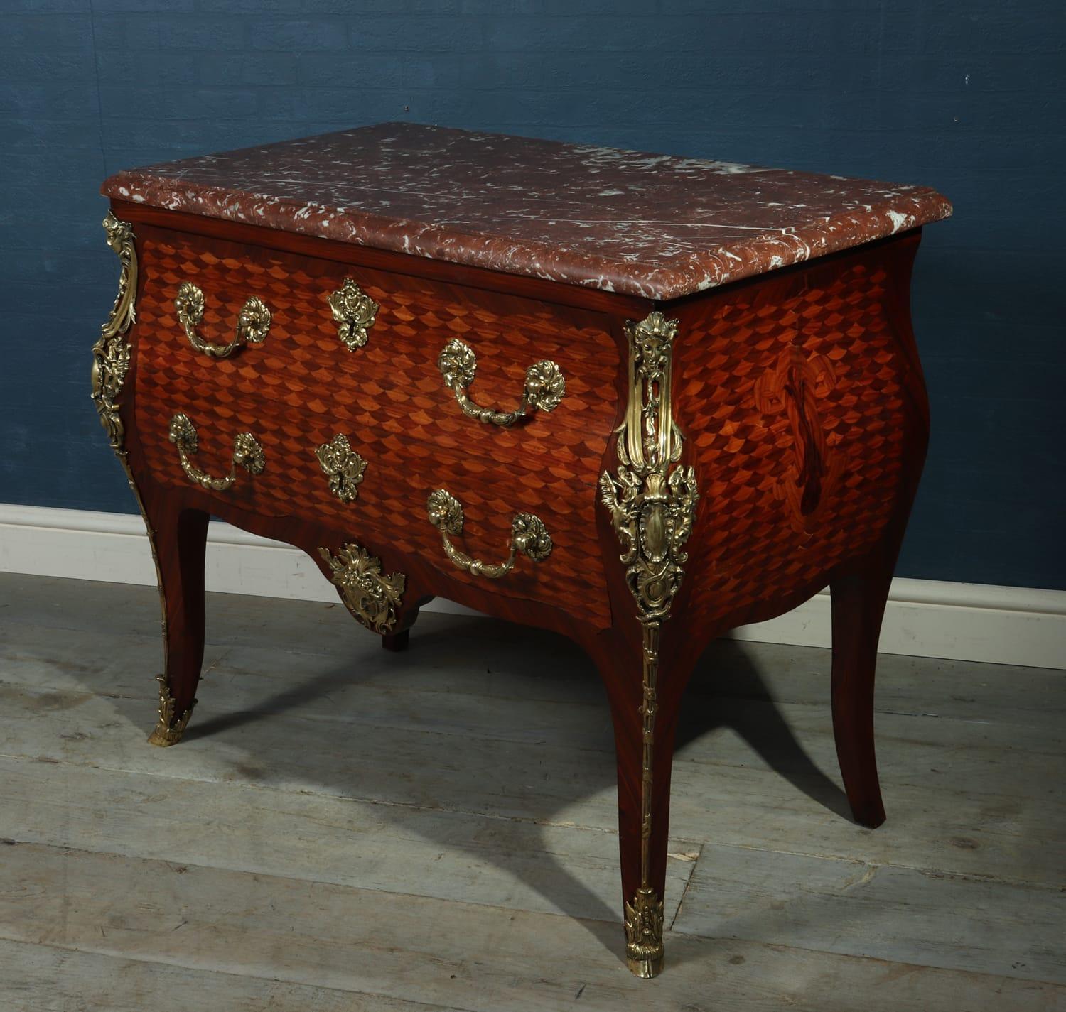 French antique commode with gilt bronze ormolu, circa 1860

This Louis XV style commode was produced circa 1860 from solid oak with intricate rosewood parquetry, it has a thick rouge marble top and gilt bronze handles and ormolu, the chest has