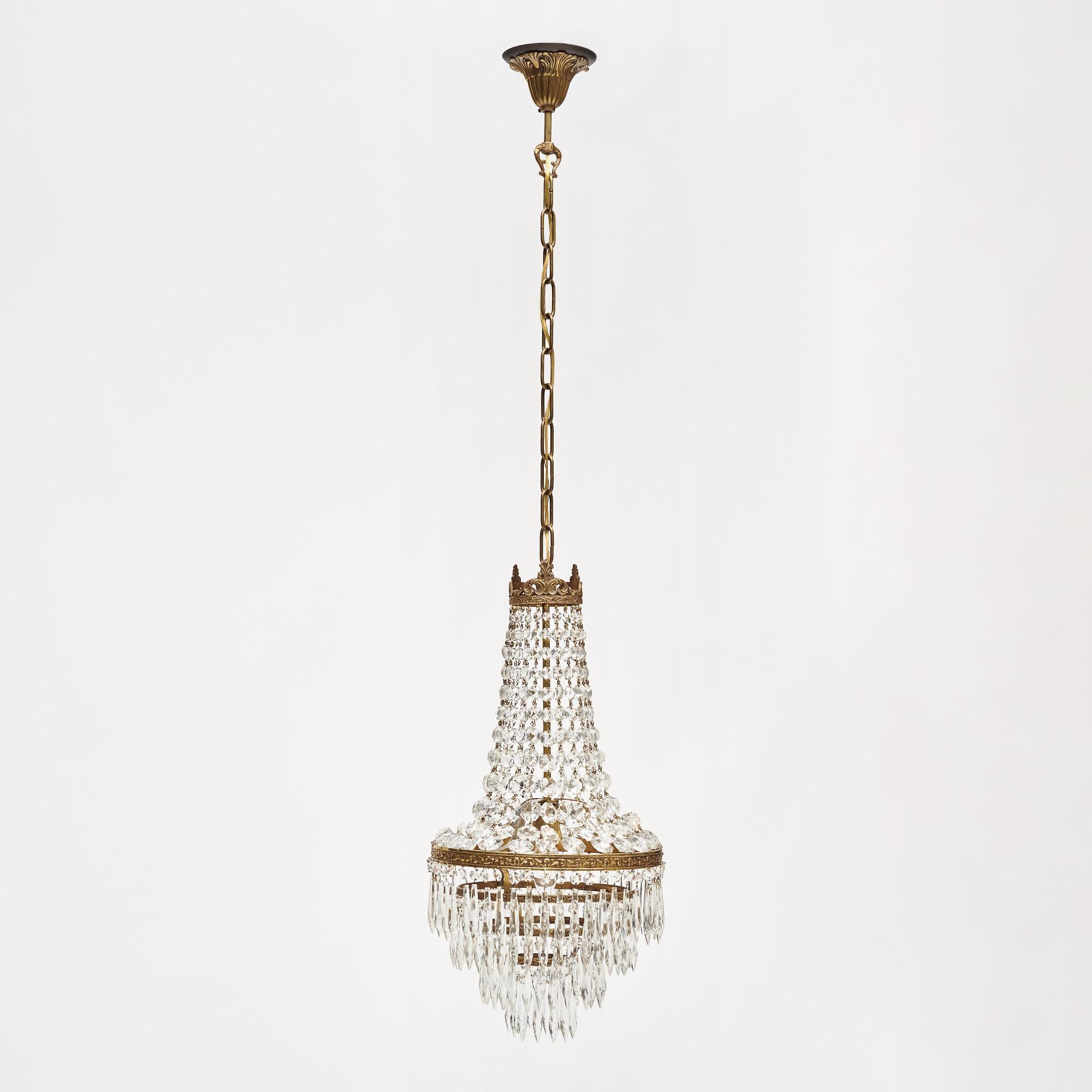 Antique chandelier from France made with cut crystal elements of cabochons and pendants. They are displayed on a brass structure. It has been newly wired to fit US standards and is in very nice antique condition with only minor surface wear