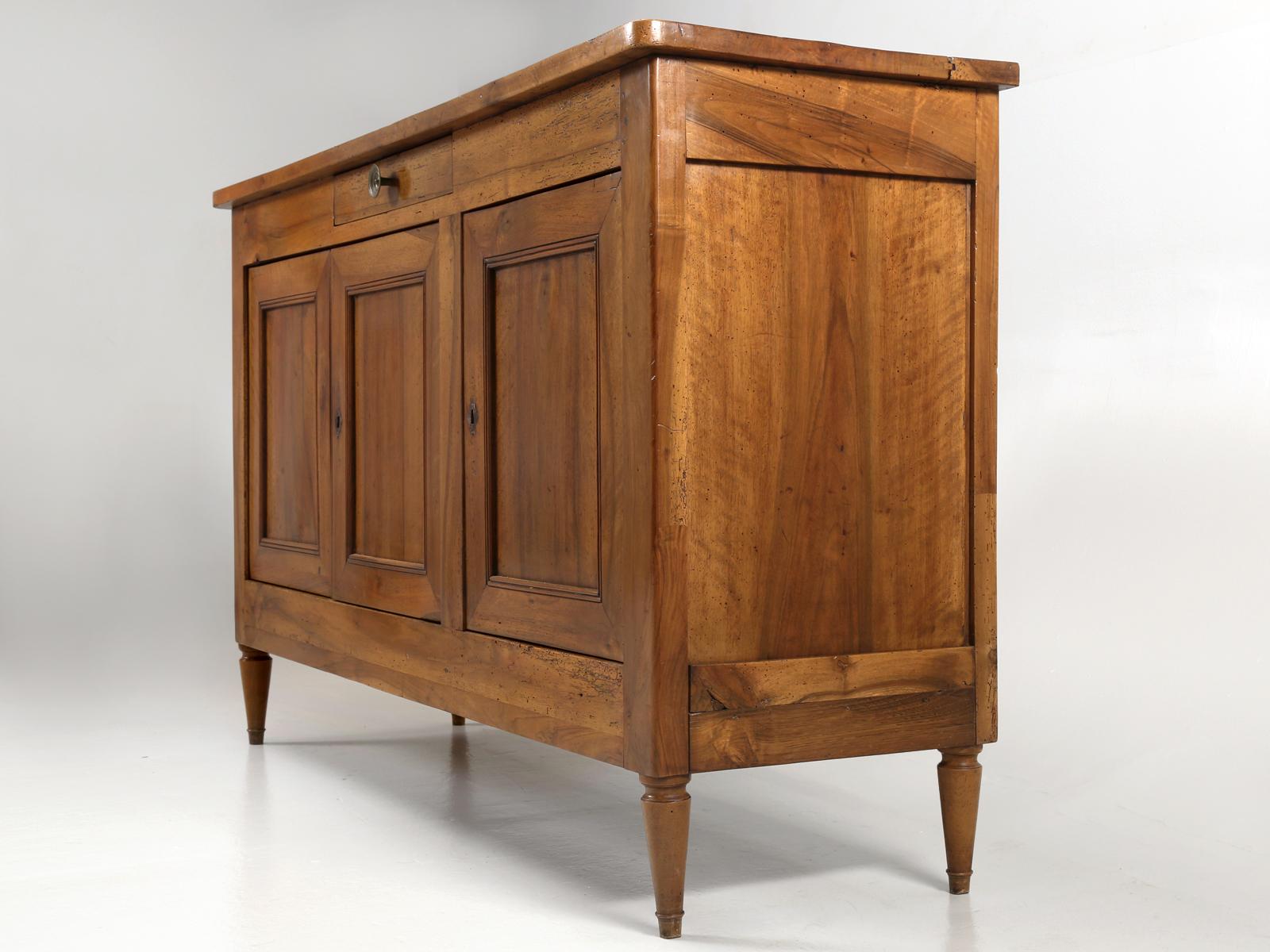 Antique French walnut Directoire style buffet, that has been sympathetically restored. Structurally, because of how old this French Directoire buffet is, we had to disassemble the entire cabinet and restore all the joints, while at the same time,