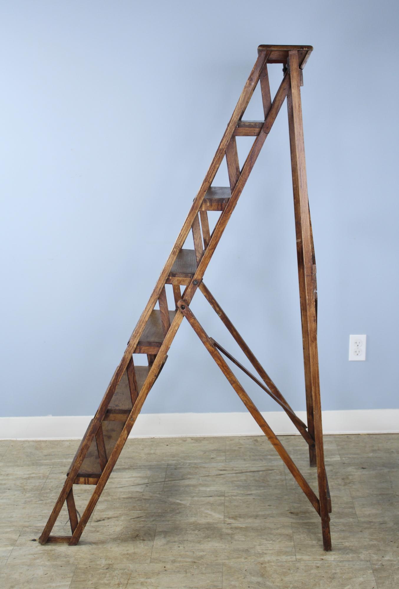 A sturdy French stepladder or set of library steps in elm with wonderful patinated hinges, a good opening mechanism and interesting distress. Quite sturdy for use with no wobbling. Good color and a good look for any room. Measurements below are for