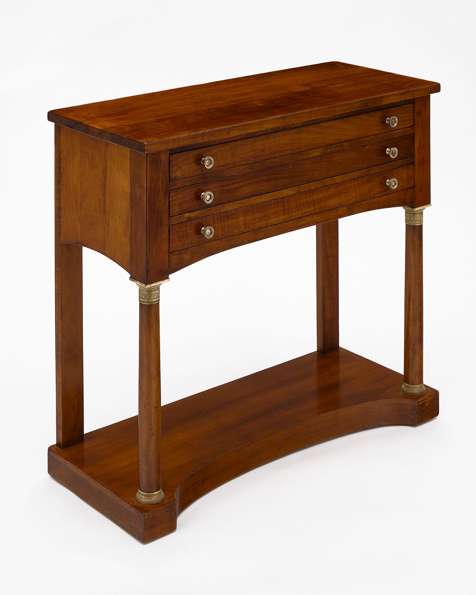 French antique Empire console table or “argentier” made of mahogany with oak as a secondary wood. We love the French Empire style and the three dovetailed drawers featuring finely cast hardware. This is a striking piece!