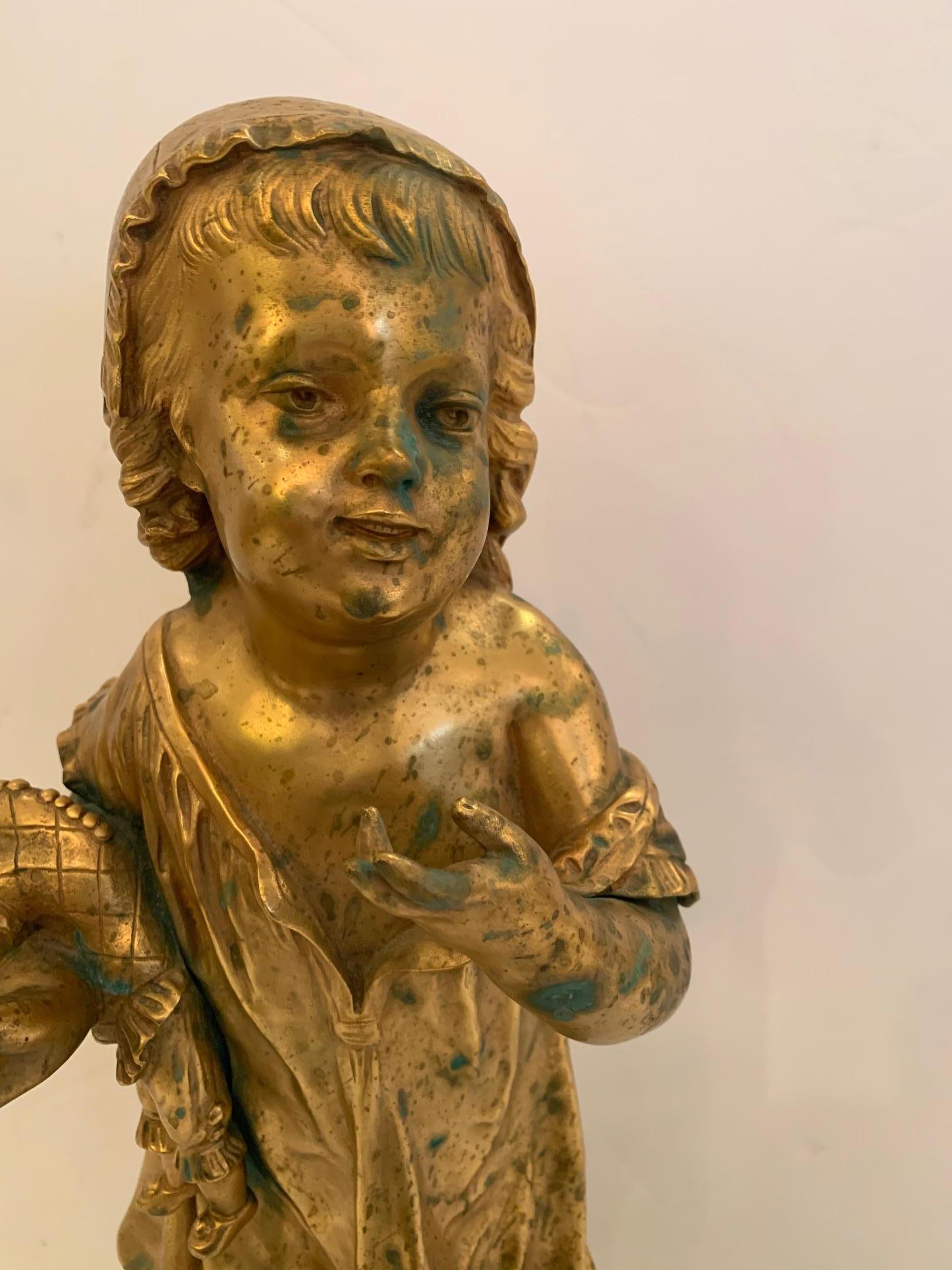 A gorgeous antique bronze figure of a young girl holding a clown doll and candle, signed Masse, (1855-1913) on the base and engraved 