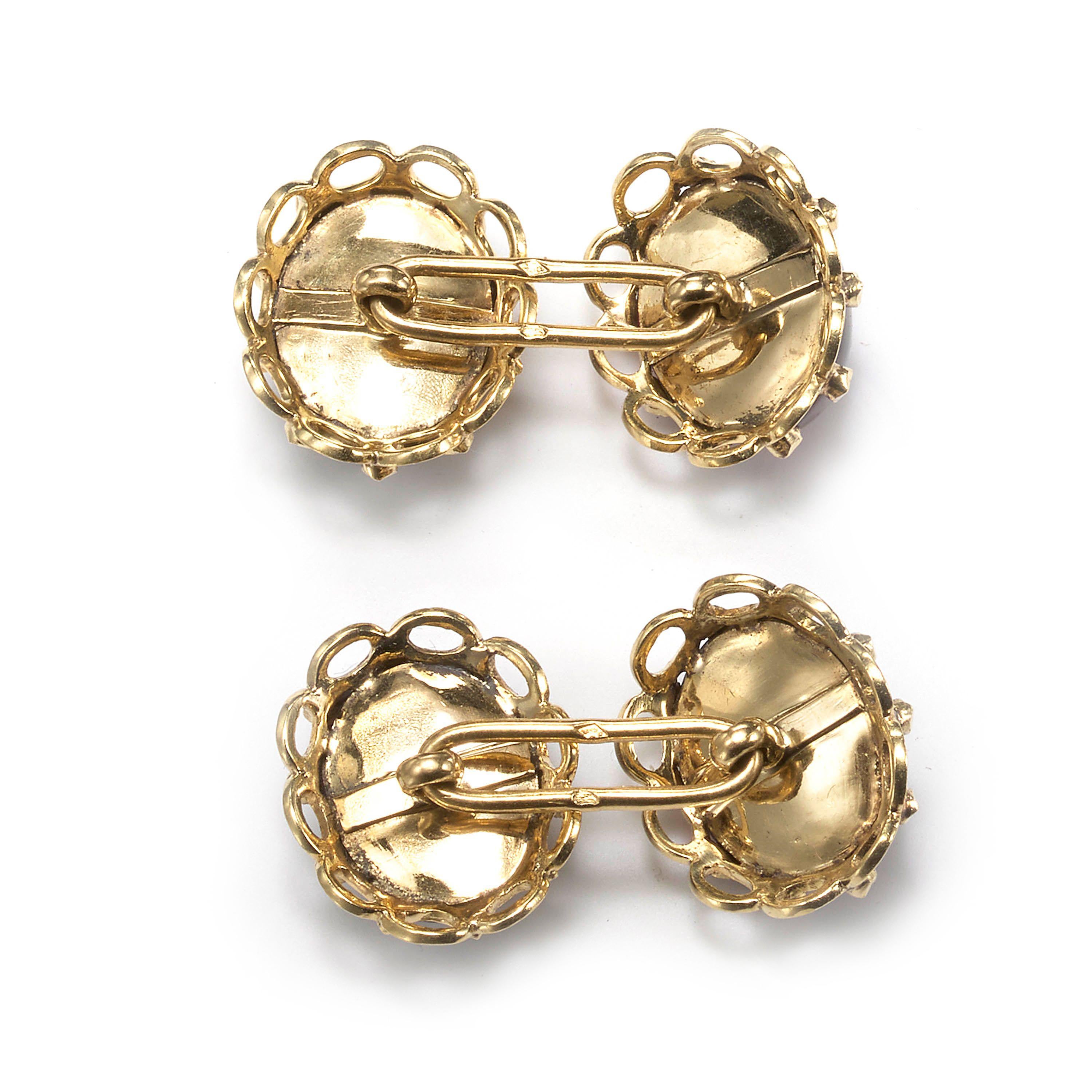 A pair of French antique cabochon garnet, diamond and gold cufflinks, with carbuncle cabochon-cut almandine garnets, surrounded by rose-cut diamonds, with a border of oval loops of gold, mounted in yellow gold with French eagle head marks for 18ct