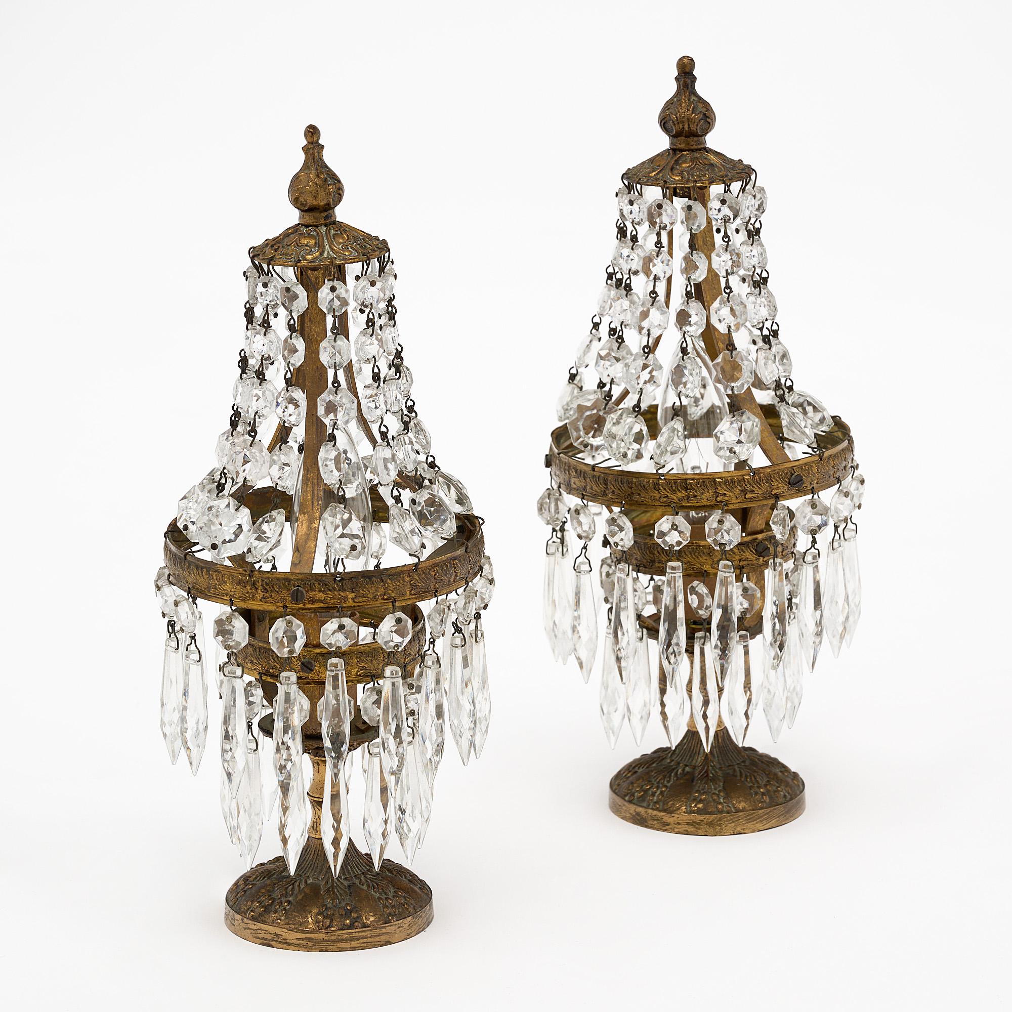 Pair of “girandoles” lamps, French, of finely cast brass. The lights include an array of cut crystal “cabochons” and pendants. They have been newly wired to fit US standards.