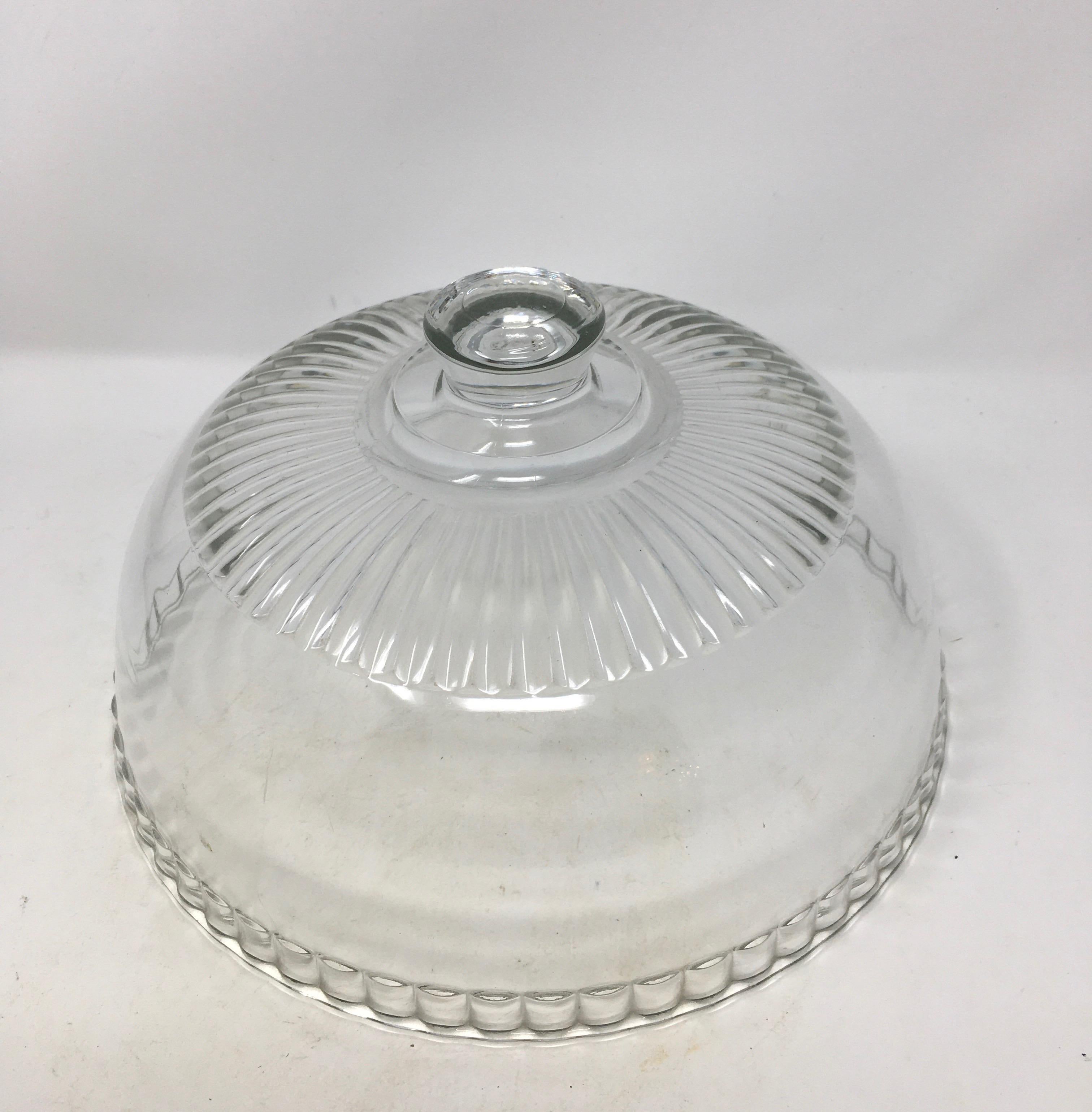 French antique glass dome cloche with a solid glass knob handle. Smooth and polished glass, these were used in French cheese shop's and patisseries to cover and display cheeses and baked goods.

This piece weighs 3.5 lbs.