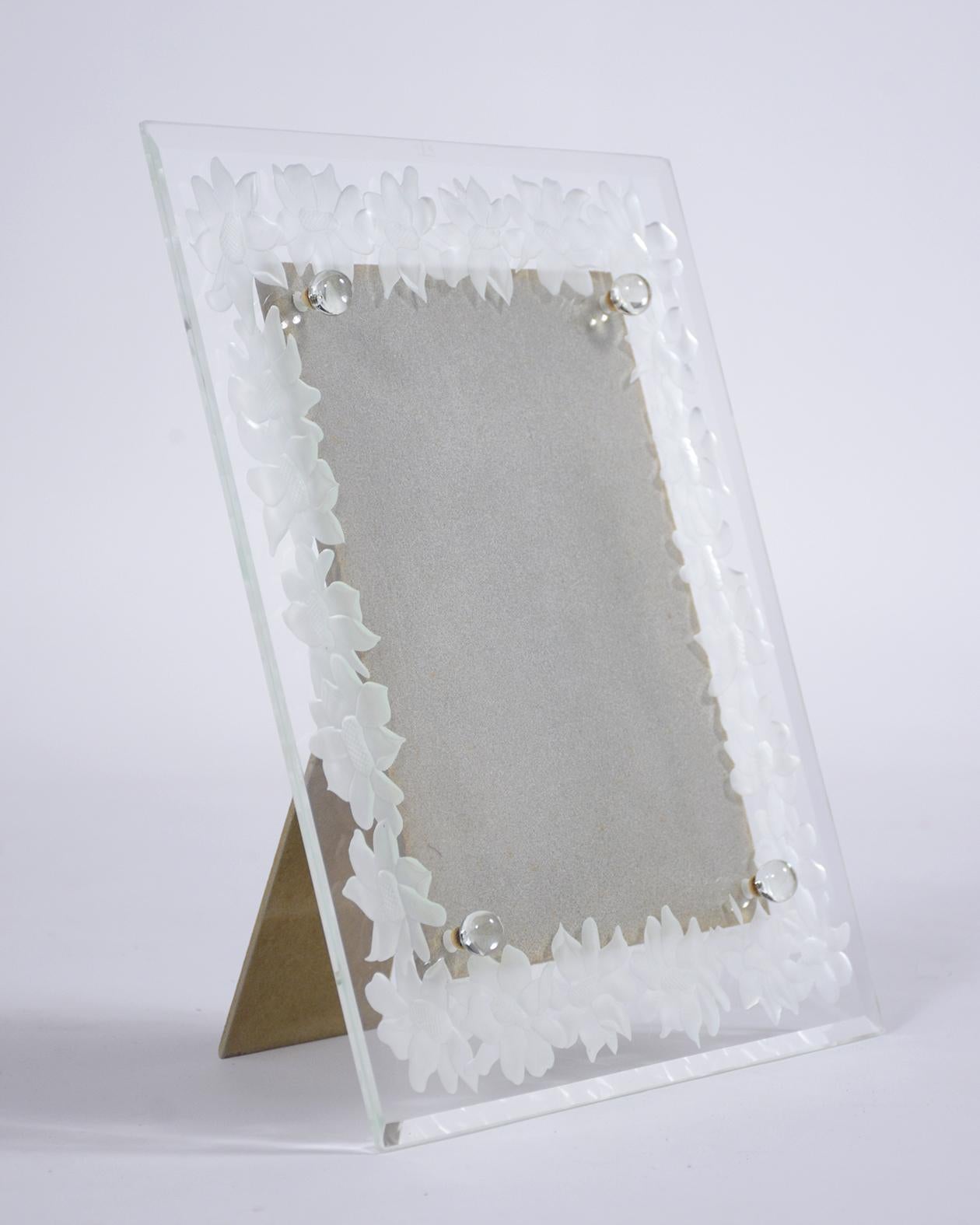 This late 19th-century glass portrait frame is in excellent condition and showcases an elegant glass frame with a beveled edge and glass etching depicting a beautiful floral border design. The stand is made out of wood and is very stable. This