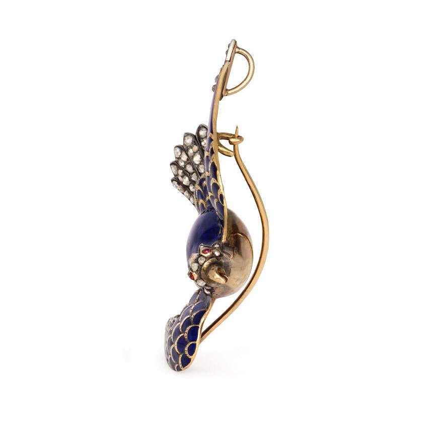 An antique brooch designed as a winging blue enamel swallow with rose diamond embellishment on the head and body, in sterling silver and 18k gold; wearable also as a pendant. France