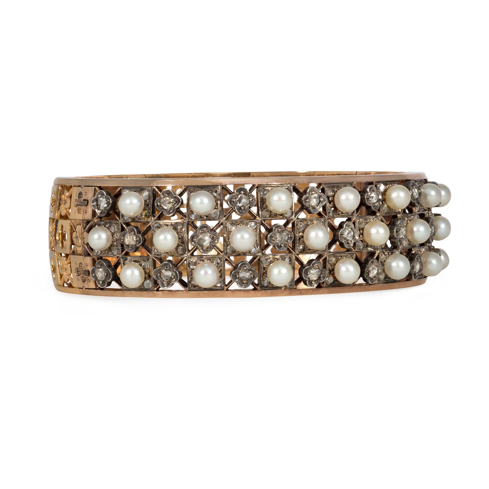 An antique gold, pearl, and diamond cuff bracelet of openwork, lattice design, the front featuring alternating pearls and rose diamonds, with each diamond in a quatrefoil setting, and the back featuring an open lace pattern of alternating quatrefoil