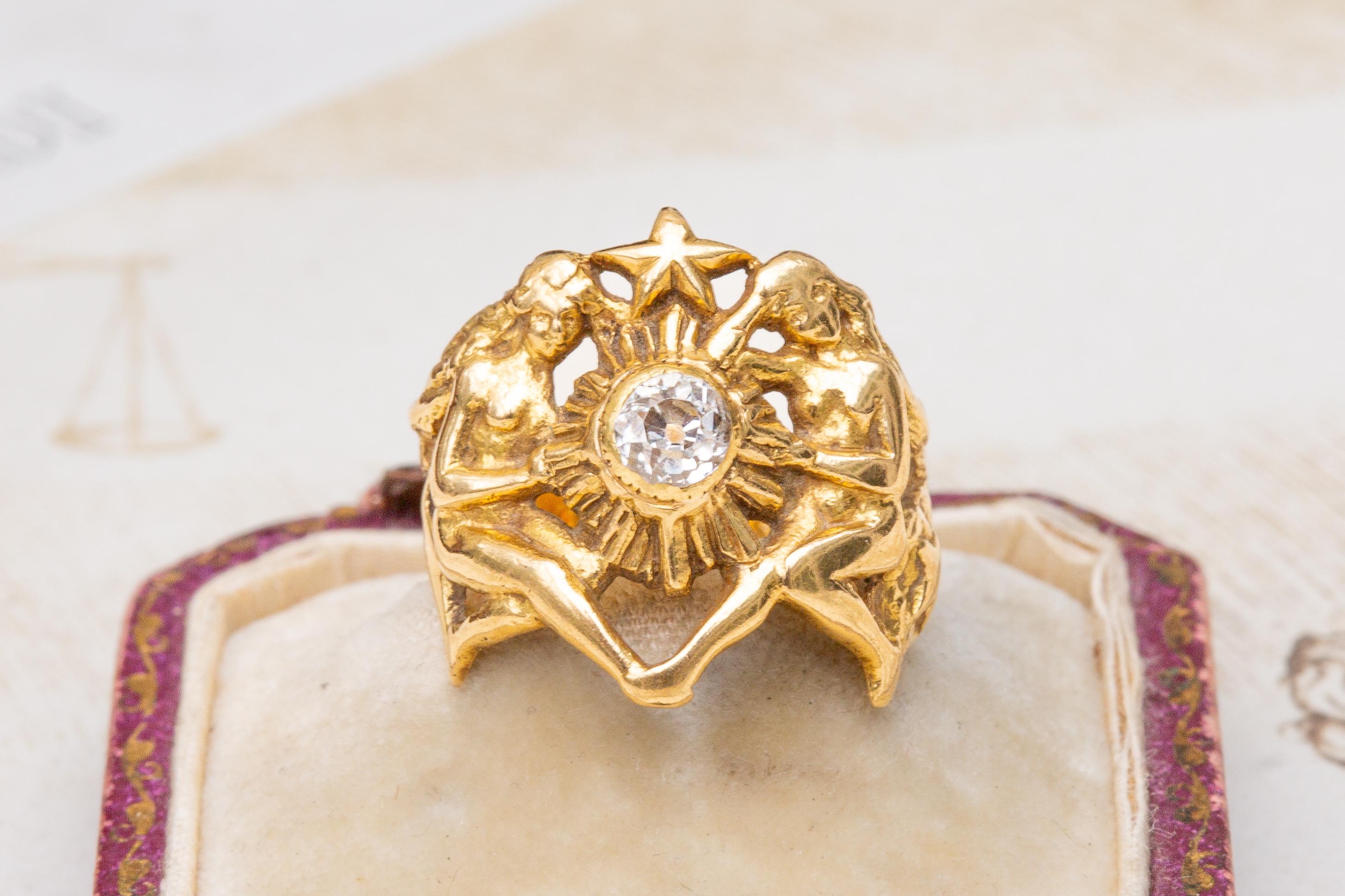An iconic example of French Art Nouveau jewellery, this sculptural statement ring was made in Paris and dates to circa 1900. This unusual figural ring is crafted in 18K yellow gold and features two highly rendered nude ethereal nymphs who appear to