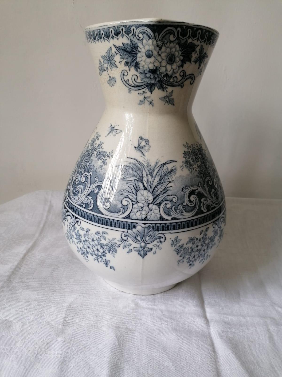 Very old Jug, burgundy earthenware, Neptune model, blue transferware. A rare piece for earthenware lovers. It is in very good condition. A rich and perfectly executed decor. Graceful cherubs, flowers, butterflies, a rich and perfectly executed