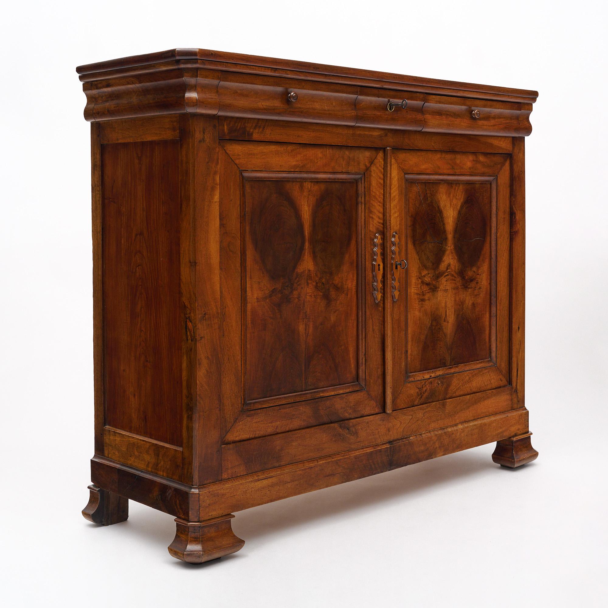 Buffet from the Louis Philippe period in France. This piece is made of burled walnut book matched on the door panels. It is from the Rhone Valley. The three drawers are dovetailed and softened by the 