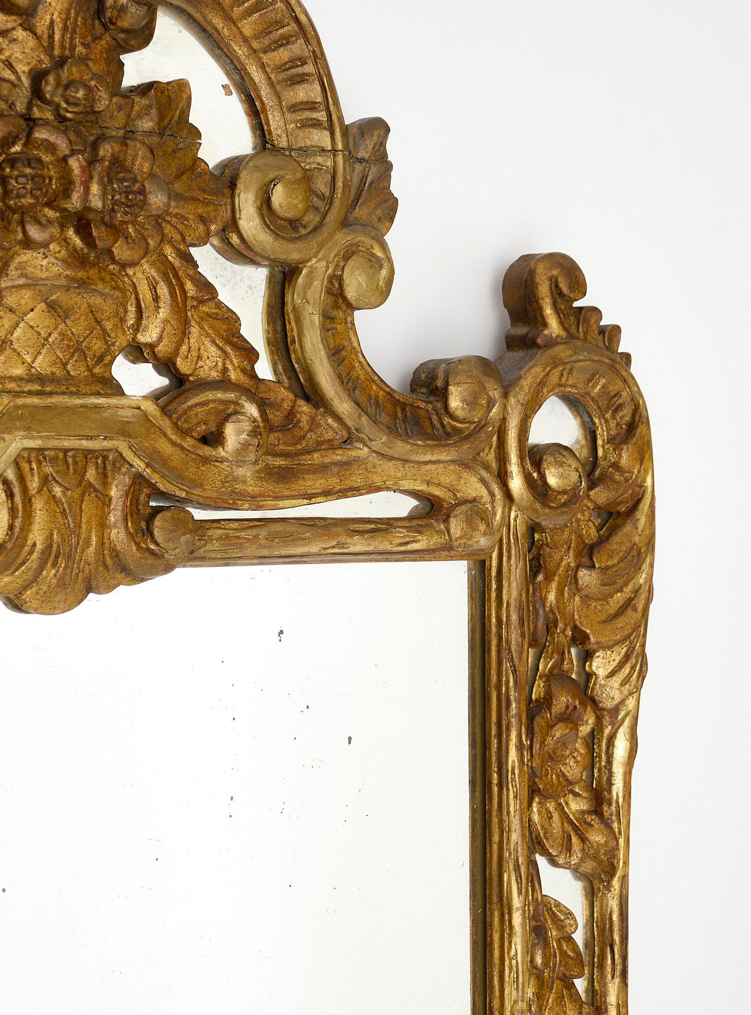Mirror from France in the Louis XIV style. This “Pareclose” mirror is covered in rich 23 carat gold leafing throughout and features interlacing designs of flowers and leaves throughout. The mirror is all original to this piece.