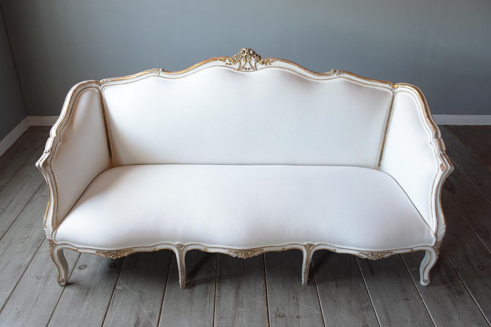 An extraordinary late 19th century Louis xv gilt sofa in great condition is handcrafted out of walnut wood and has been completely restored by our team of expert craftsmen. This beautiful sofa features a beautiful hand gilt painted finish