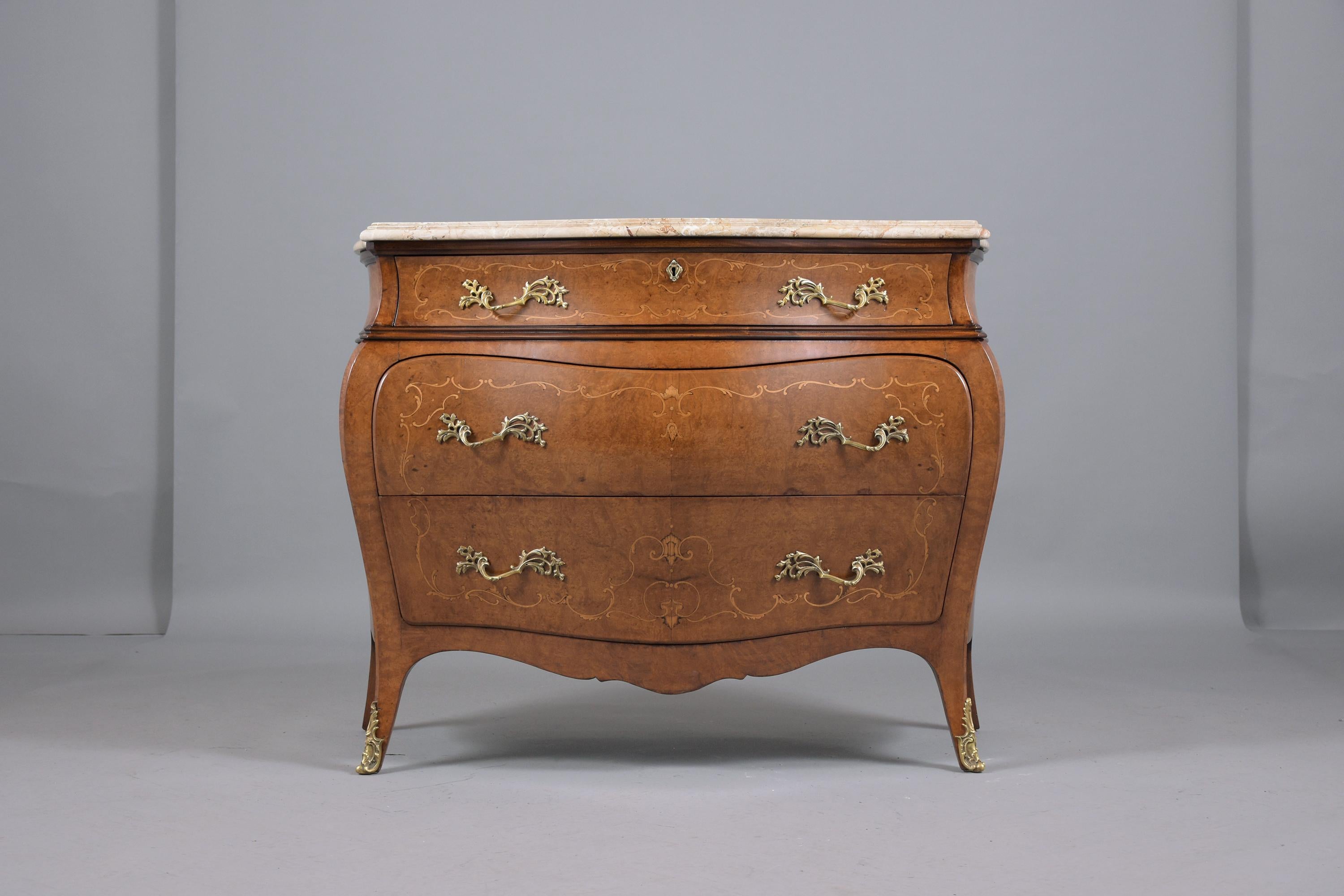 This excellent French 1910's chest of drawers is hand-crafted out of fruitwood professionally restored by our craftsmen team in the house. This serpentine style commode features a beige color bevel marble top, and elegant inlaid details throughout