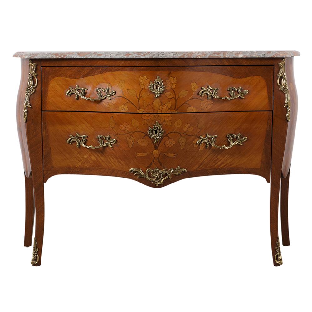 This Late 19th Century French Louis XV Style Commode is made out of solid wood with its original mahogany stain, has been waxed giving it a beautiful patina finish, and is in good condition. The Chest of Drawers features a multicolored beveled