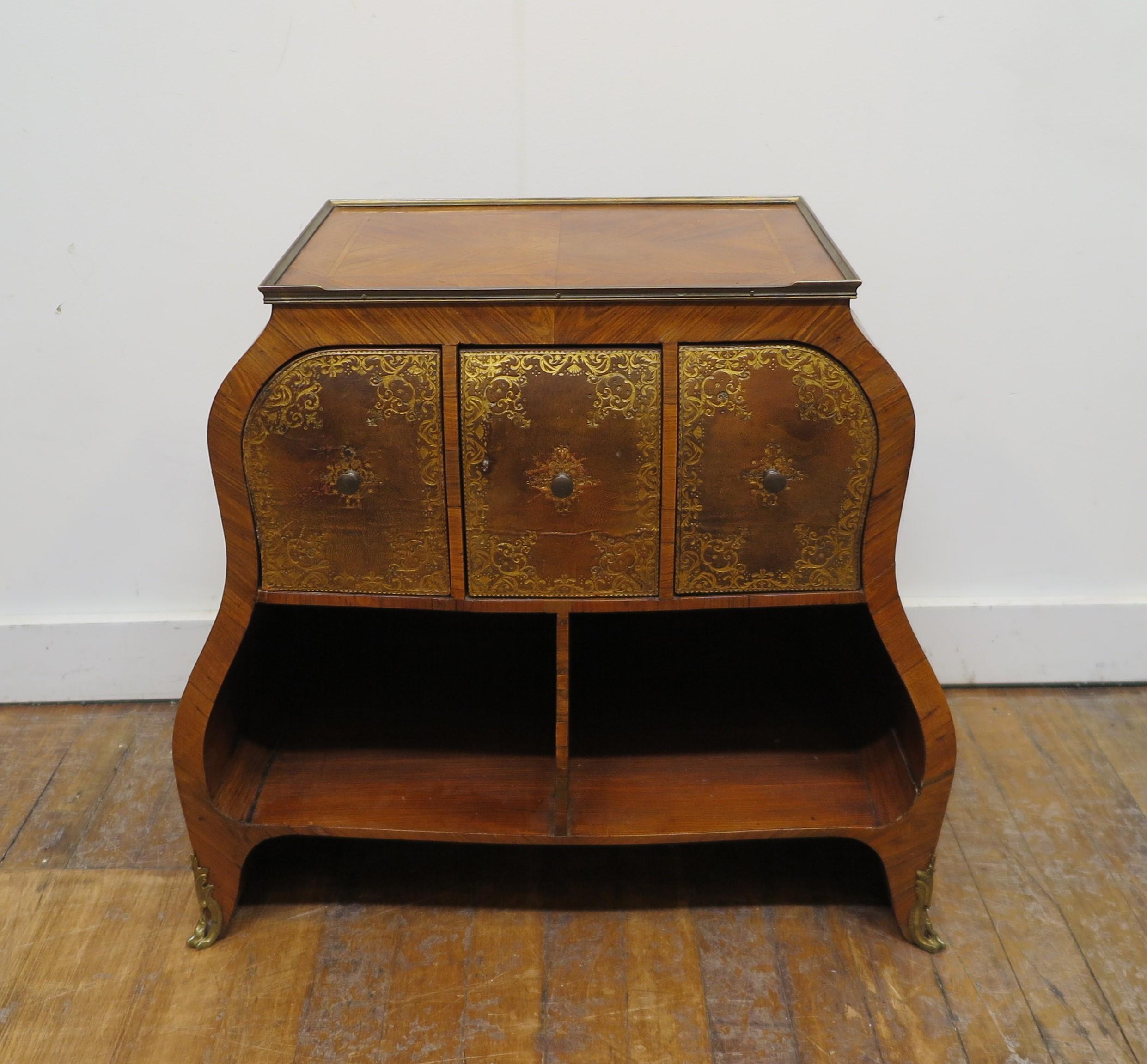 French antique side table in the style of Louis XV with three leather embossed drawers and two lower compartment shelfs. Stunning marquetry work adorn a beautifully shaped body with solid brass trim detail top and feet. The design workmanship to the