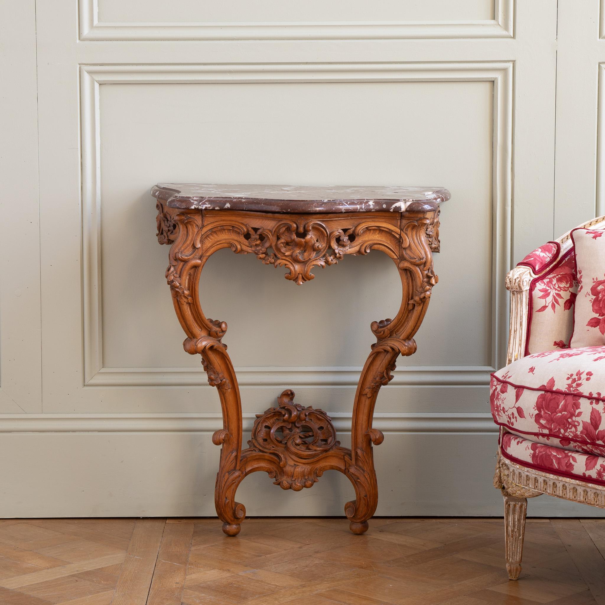 Französische Konsole im Louis-XV-Stil aus dem frühen 19. Jahrhundert, handgeschnitzt in Nussbaum. Das Holz hat einen schönen warmen Farbton mit honigartigen Nuancen. Die Marmorplatte 