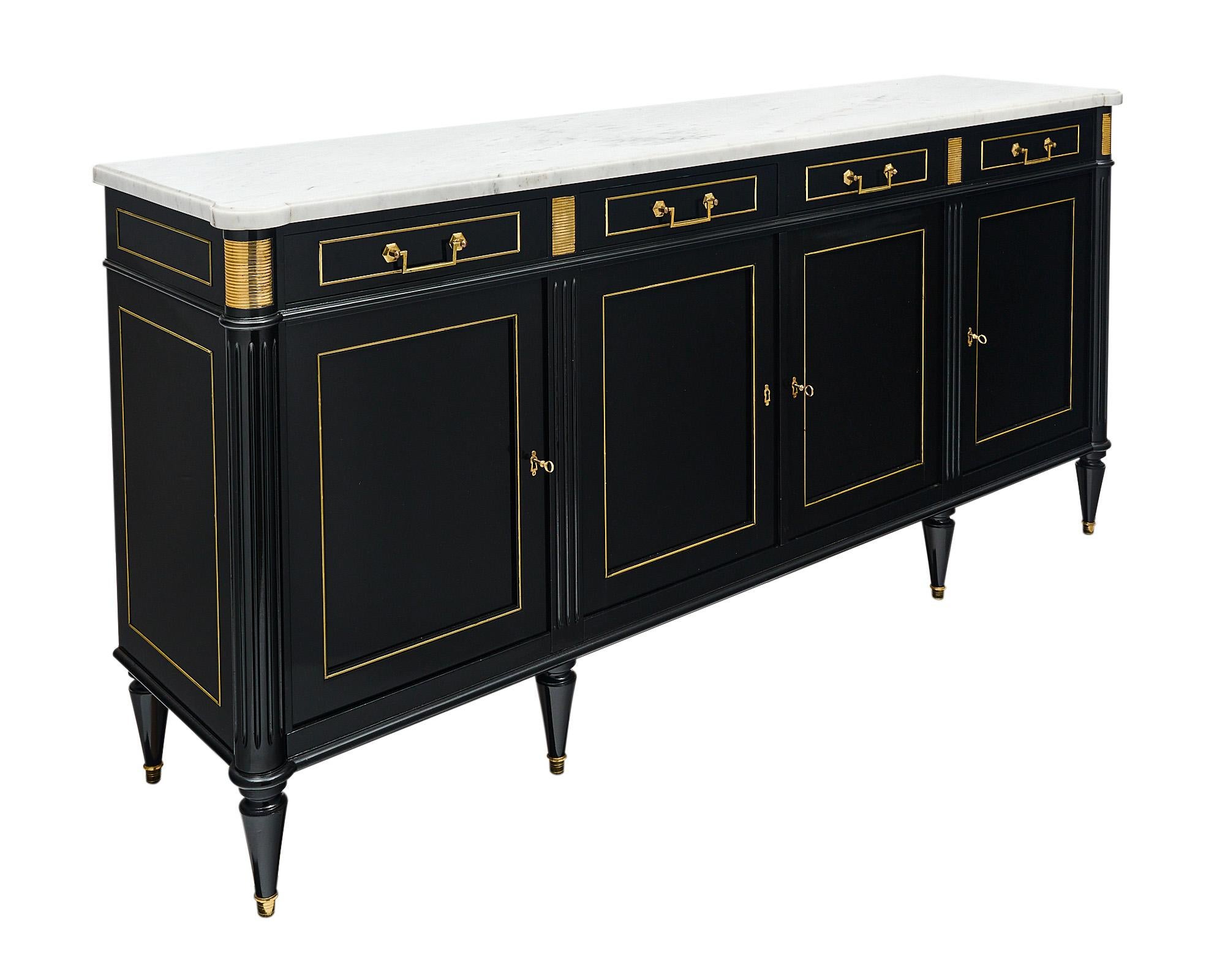 Buffet / enfilade from France made of solid mahogany that has been ebonized and finished in a lustrous museum-quality French polish. Four dovetailed drawers sit above four doors that open to interior shelving. All locks are in working condition. The