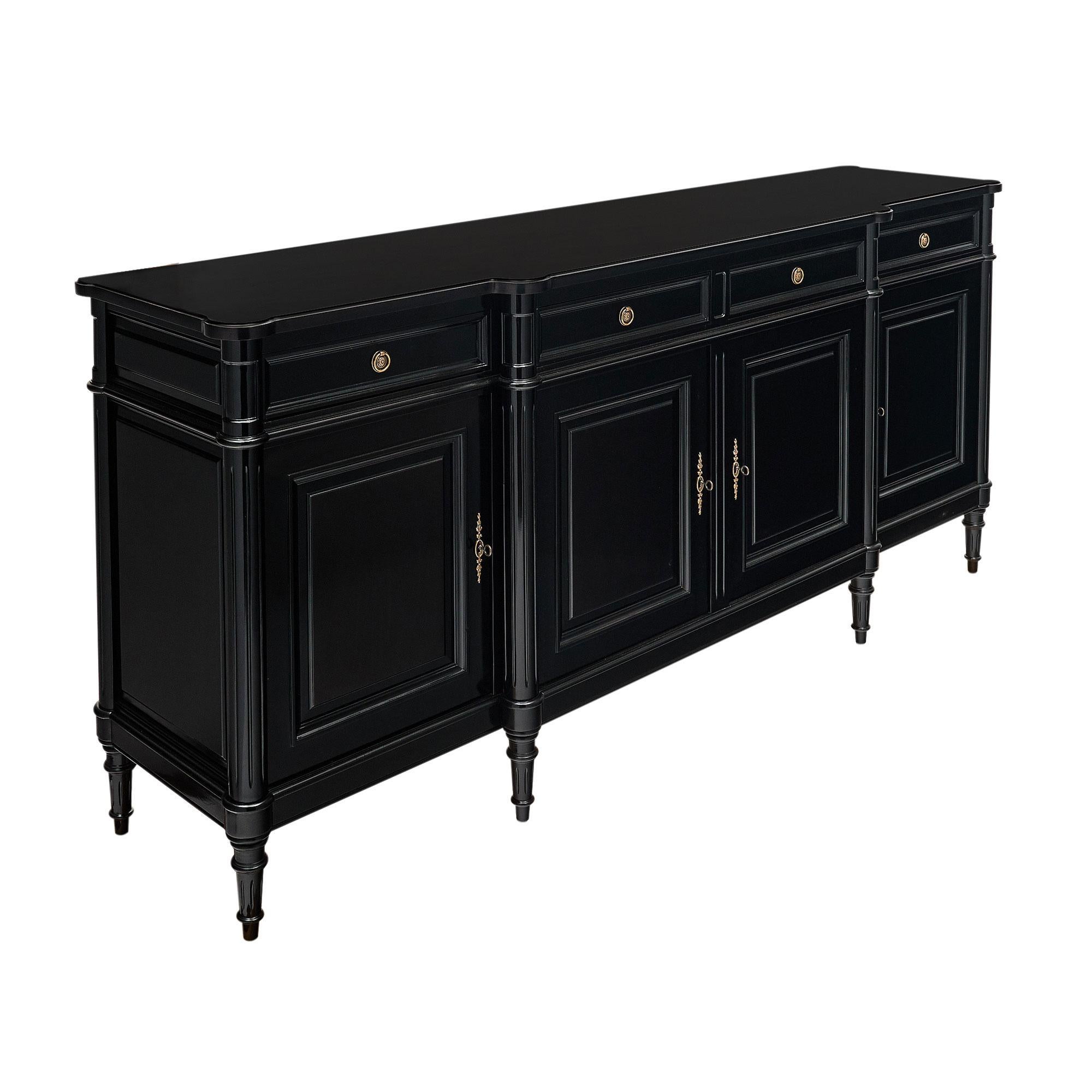 Buffet in the Louis XVI style from France, ebonized with a highly lustrous French polish finish of museum quality. This case piece has four doors that open to interior shelving and four dovetailed drawers. The hardware is all cast brass.
