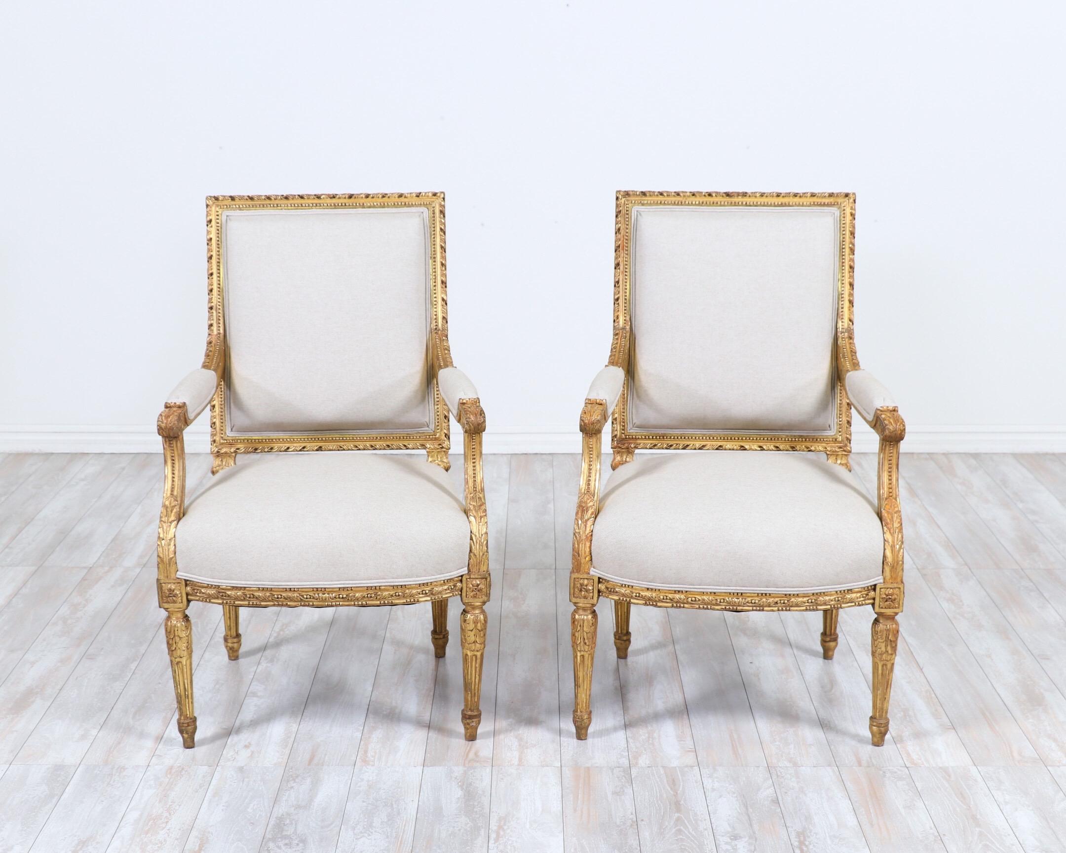 Gorgeous, 1920s French Louis XVI-style giltwood fauteuils with delicately carved decorations and new linen canvas upholstery. 

The Classic design of these antique French chairs make them perfect for traditional European to contemporary