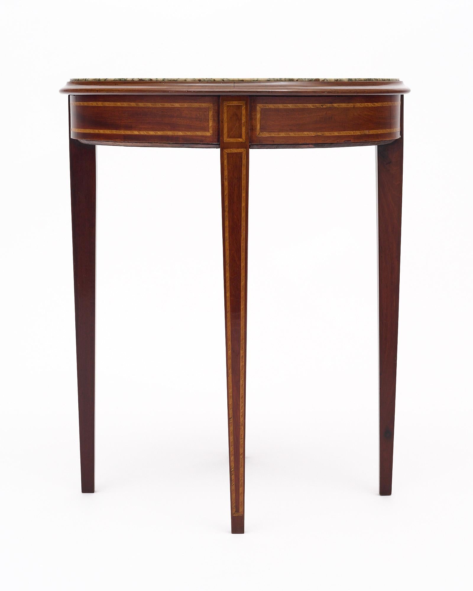 Geuridon side table in the Louis XVI style from France. This piece is made of mahogany and features inlay for a classic design. It is finished with a lustrous French polish of museum quality. Atop the piece sits an original marble top.
