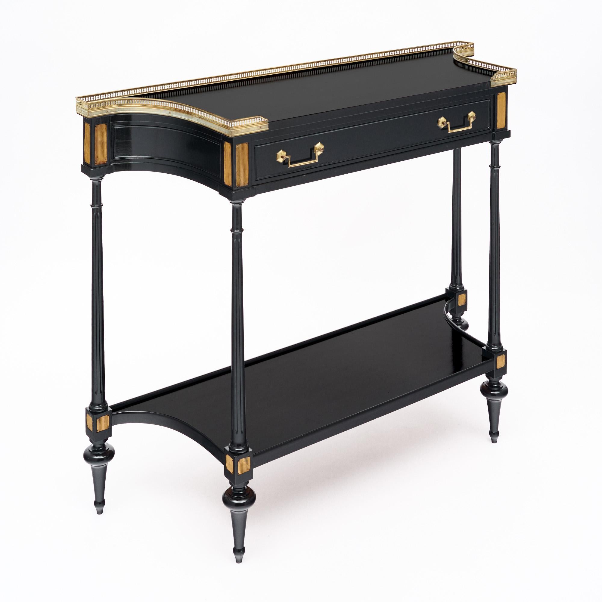 French console made of of Mahogany wood that has been ebonzied and finished in a lustrous Museum quality French polish. Featuring tapered legs and the original gilt brass hardware. The piece is in very nice antique condition with only minor surface