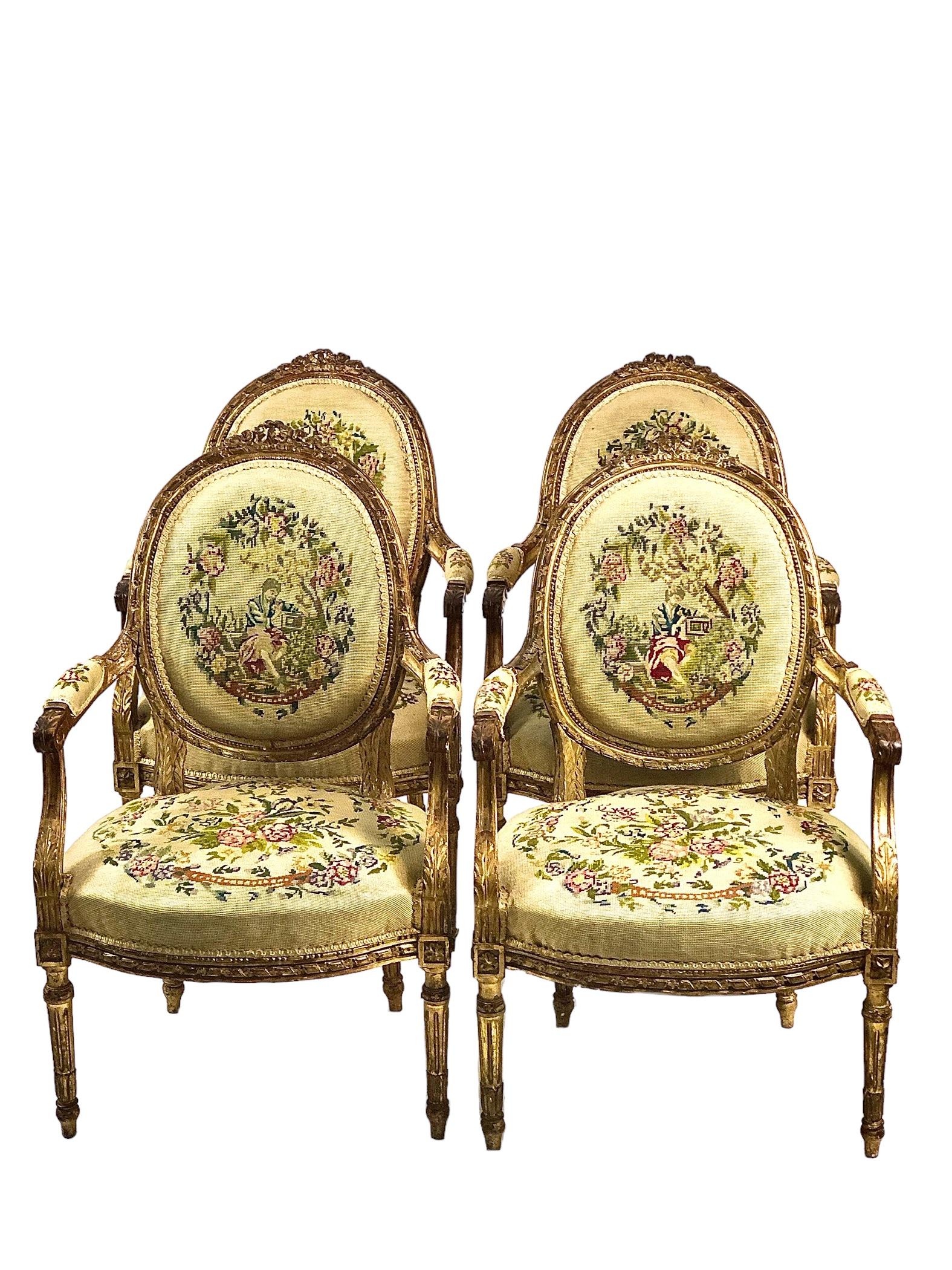 Eine exquisite Garnitur reich geschnitzter Salonmöbel aus vergoldetem Holz im Louis XVI-Stil, bestehend aus vier Fauteuil-Cabriolet-Sesseln mit ovaler Rückenlehne und einem passenden zweisitzigen Sofa. Jeder Stuhl dieses eleganten Sets ist an