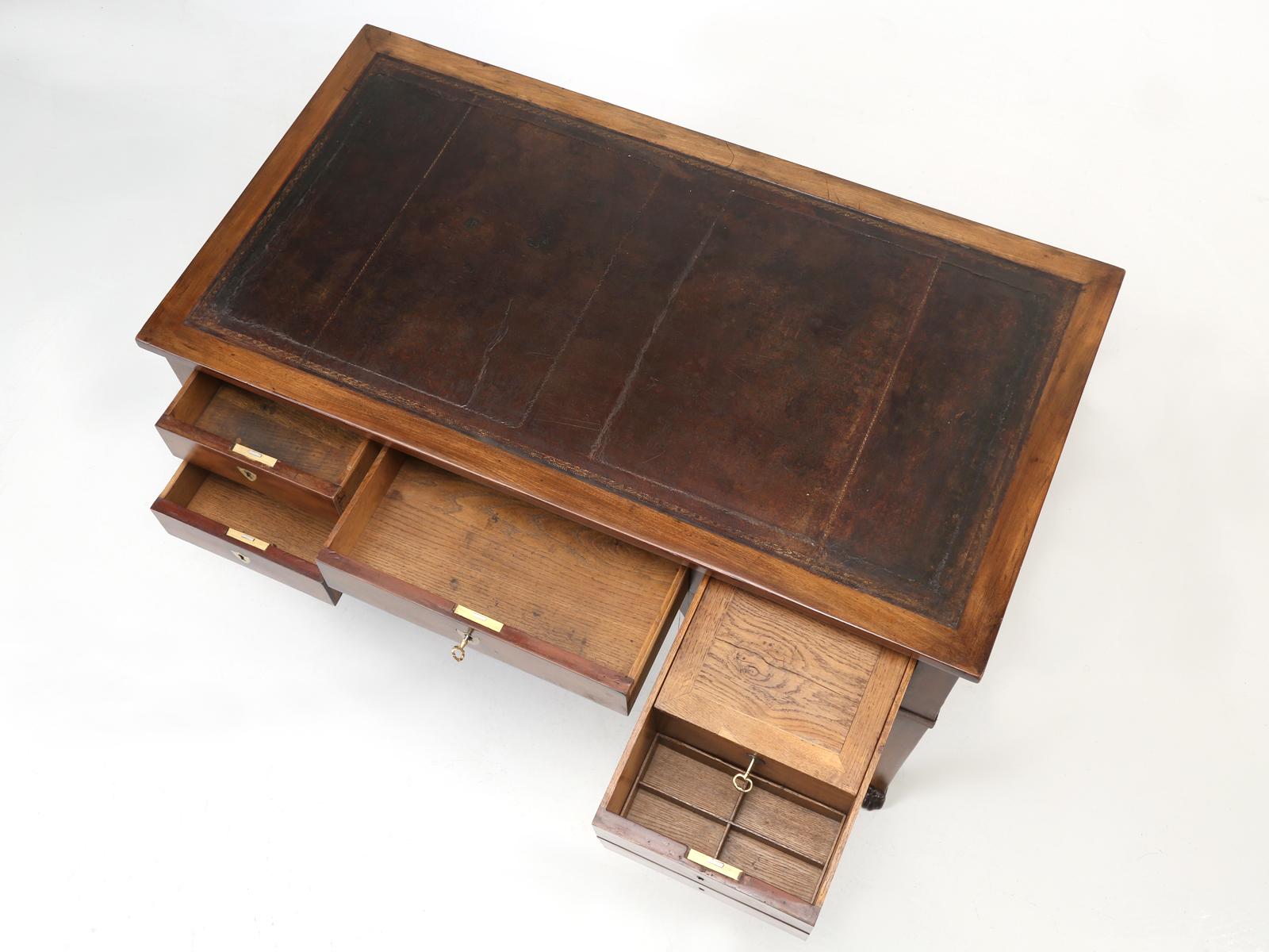 Beautiful antique French writing desk, made from mahogany with French white oak drawer interiors, circa 1880-1900. All the drawers have been thoroughly restored, and all locks actually function, with their own keys like they were intended to. Note