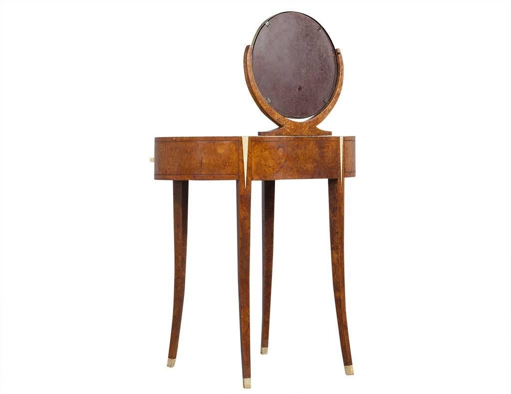 This vintage, Art Deco style vanity hails from France. The set is composed of a vanity table and matching stool and each piece is patterned with a fine bookmatched mapa burl and detailed with bone hardware and accents. Each piece is in good