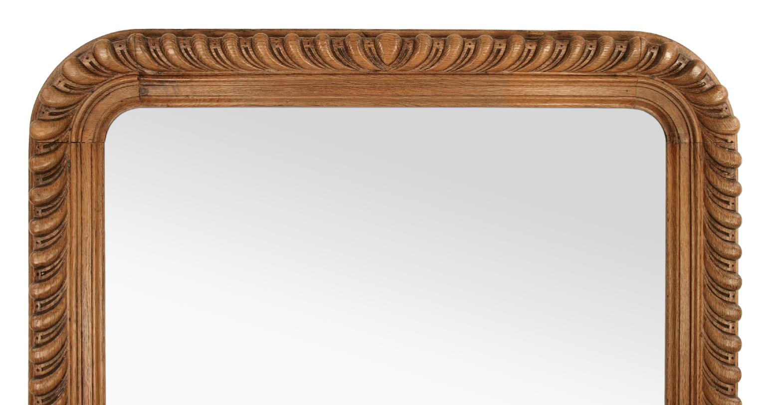 French antique mirror, Louis-Philippe style late 19th century. Carved oak wood decorated with stylized gadroons. Modern glass mirror. Antique frame width: 10 cm.