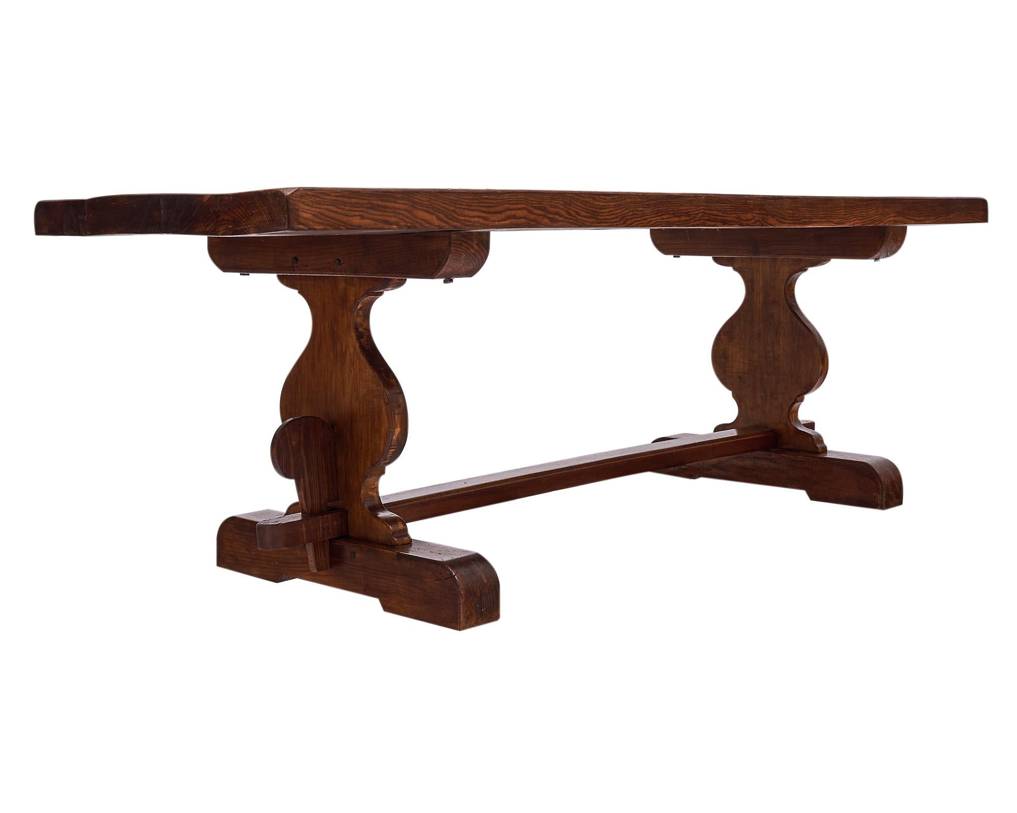 Dining table, French, made of walnut with “lyra” stylized pedestals. This piece has peg construction and is finished with a Carnauba wax finish. This piece is from the Rhone Valley.