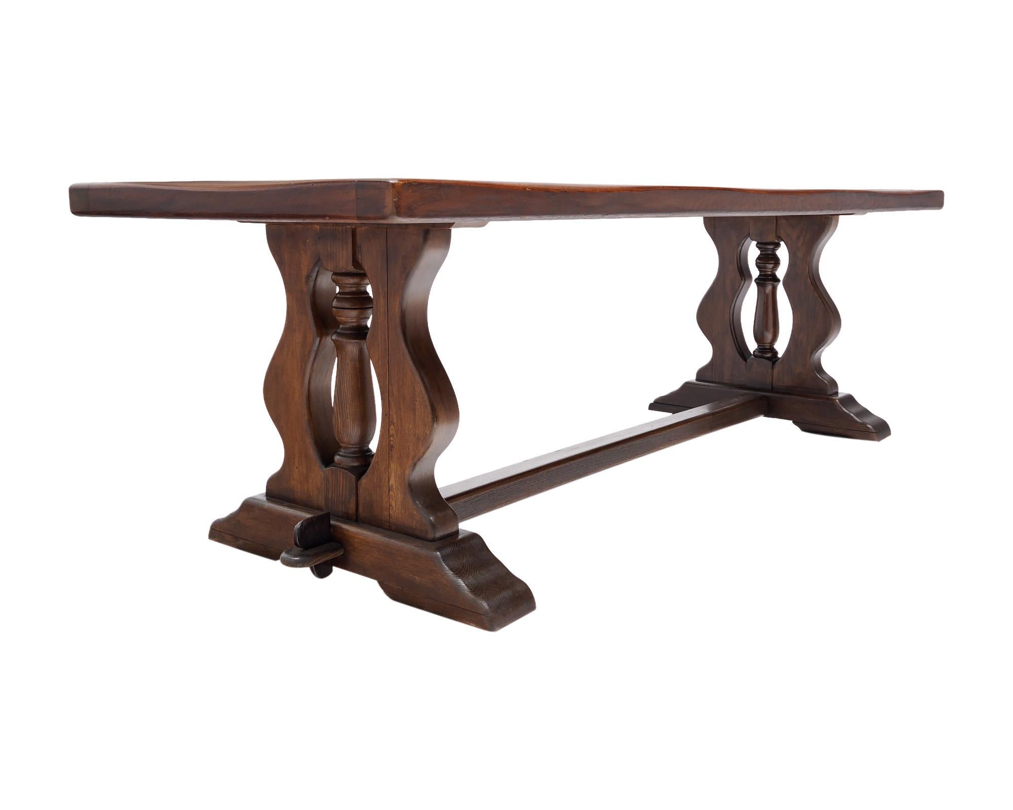 French dining table made of walnut from a monastery in the Rhone Valley, north of Lyon, France. This beautiful table has a wooden top trimmed with wood as well. There are two “Lyra pedestal legs connected with a stretcher. This piece has peg