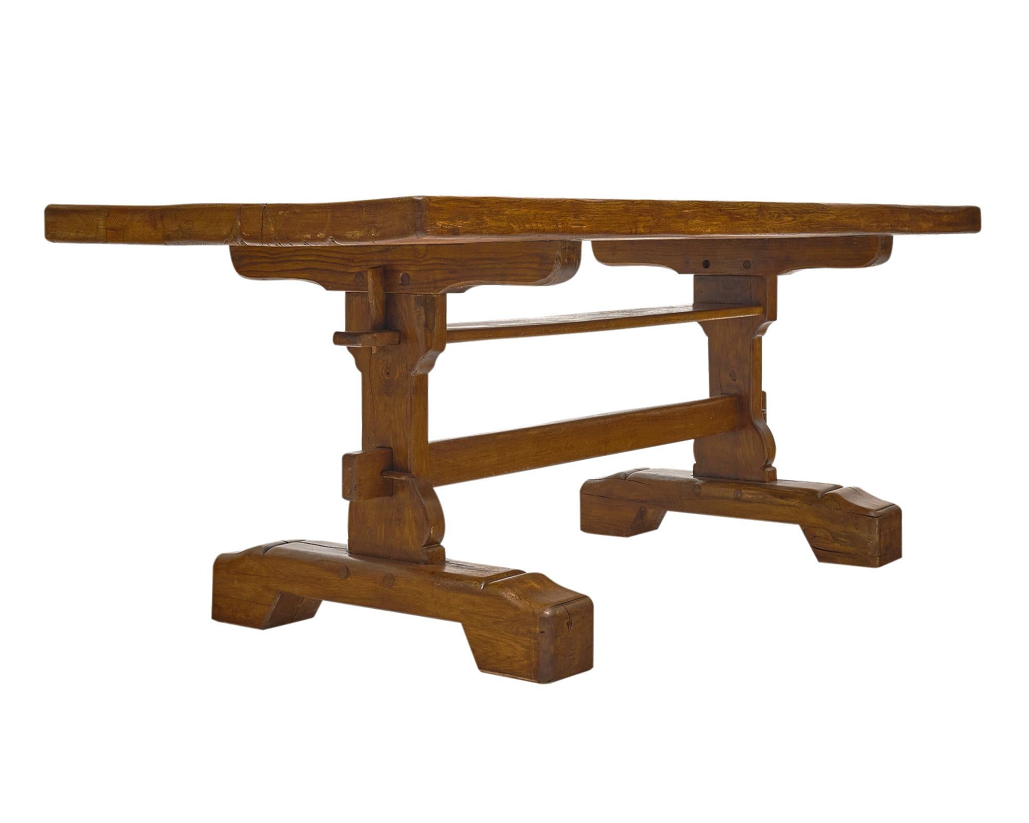 Trestle table from France handcrafted in Solid oak with a unique trestle pedestal and double stretcher. This piece has peg construction and is finished with a Carnauba wax finish. The table is from the Rhone Valley.