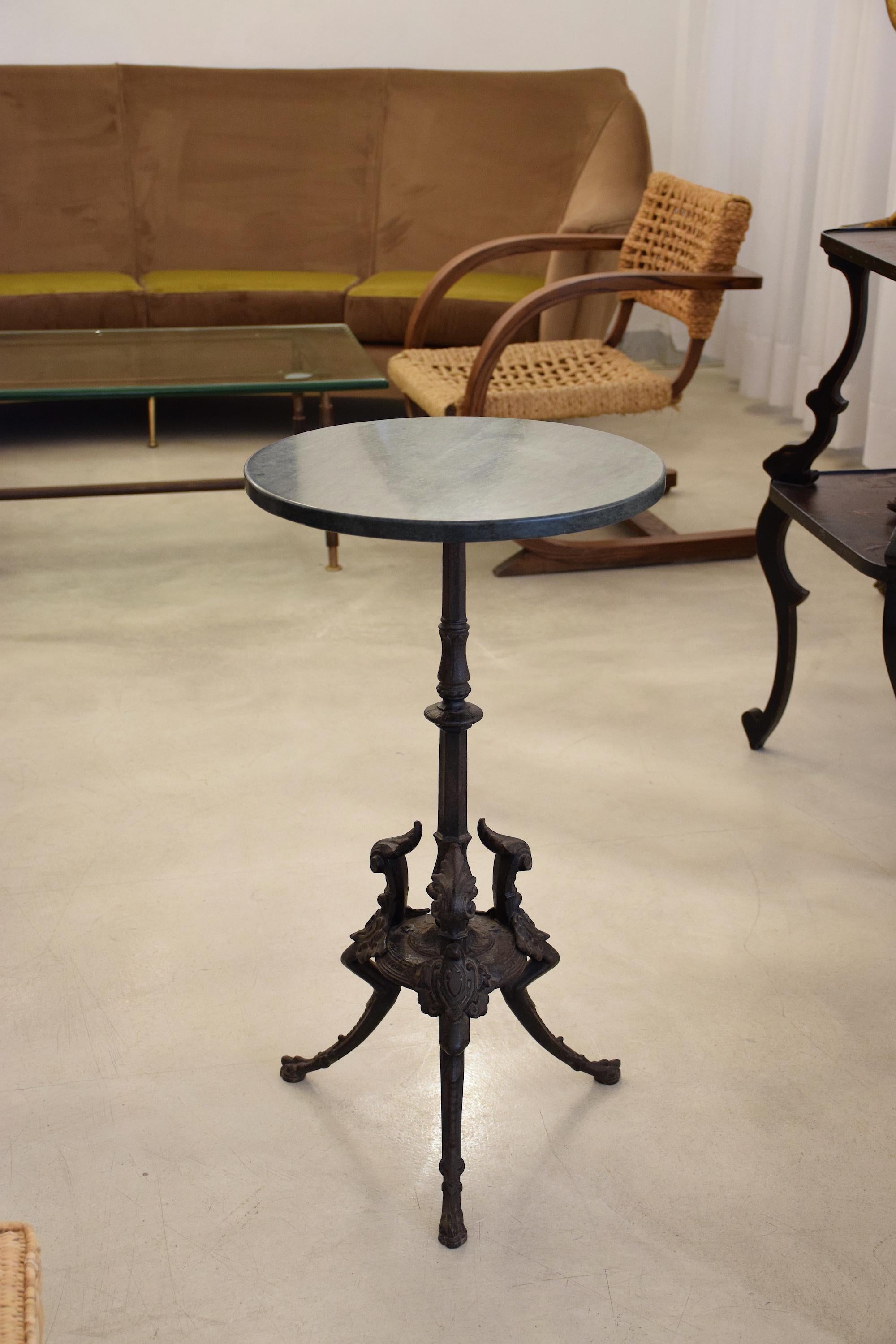 A french antique gueridon, pedestal or side table dating back to the 19th century from the Napoleon III period crafted with a black wrought iron tripod structure and intricately sculpted details with beautiful patina. Restored with a circular green