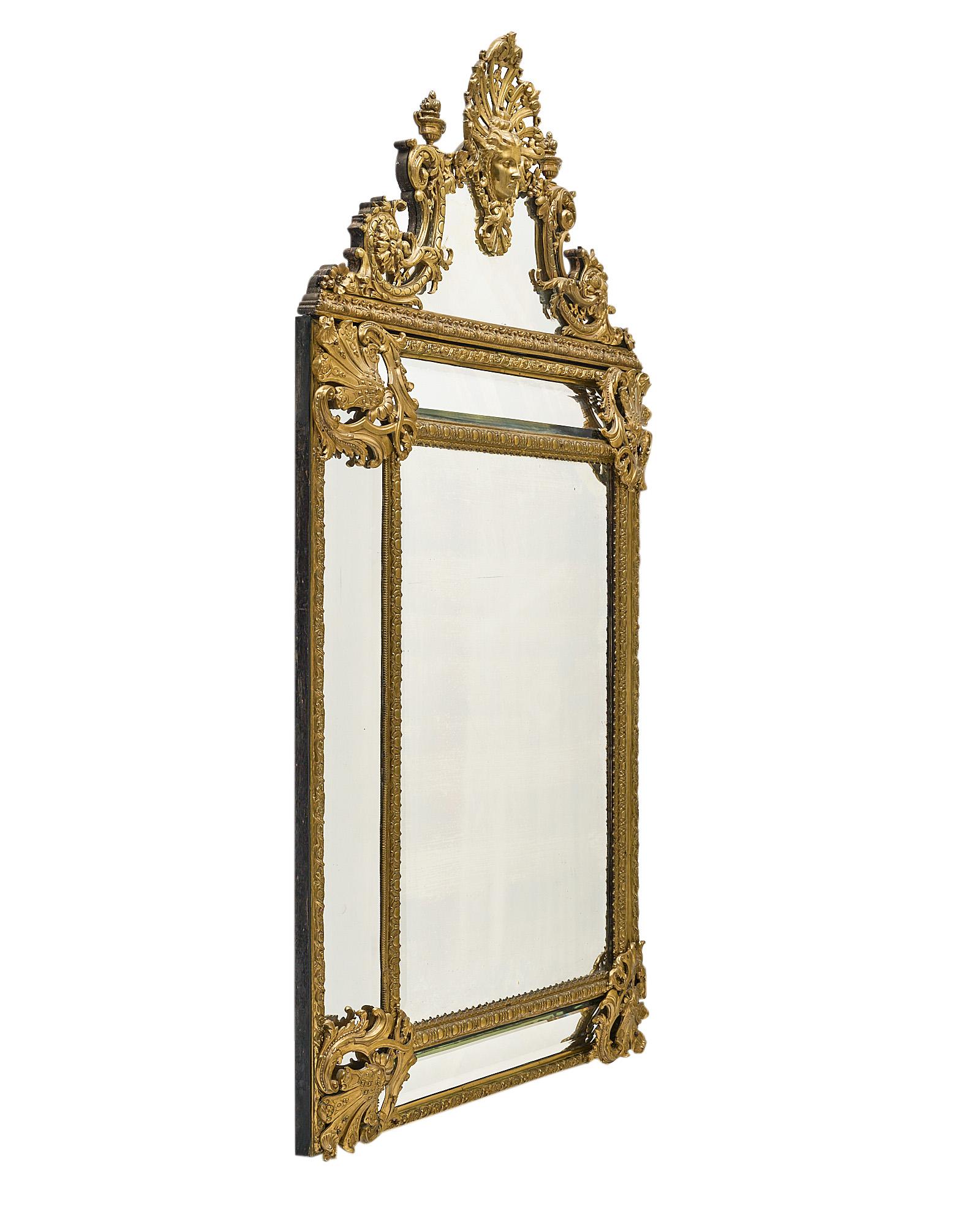 Mirror, French, from the Napoleon III period. This piece is made of finely cast bronze ormolu, with intricate decor of friezes, “godrons”, and acanthus leaves. This spectacular mirror features side compartments with the original beveled glass and a