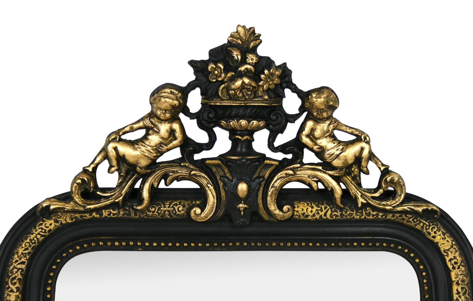 French antique mirror, Napoleon III style. Black painted and gilding to the leaf with pediment ornamented angels and flowers, decorated of pearls. Antique wood back. Modern glass mirror. Antique frame width: 7 cm.
