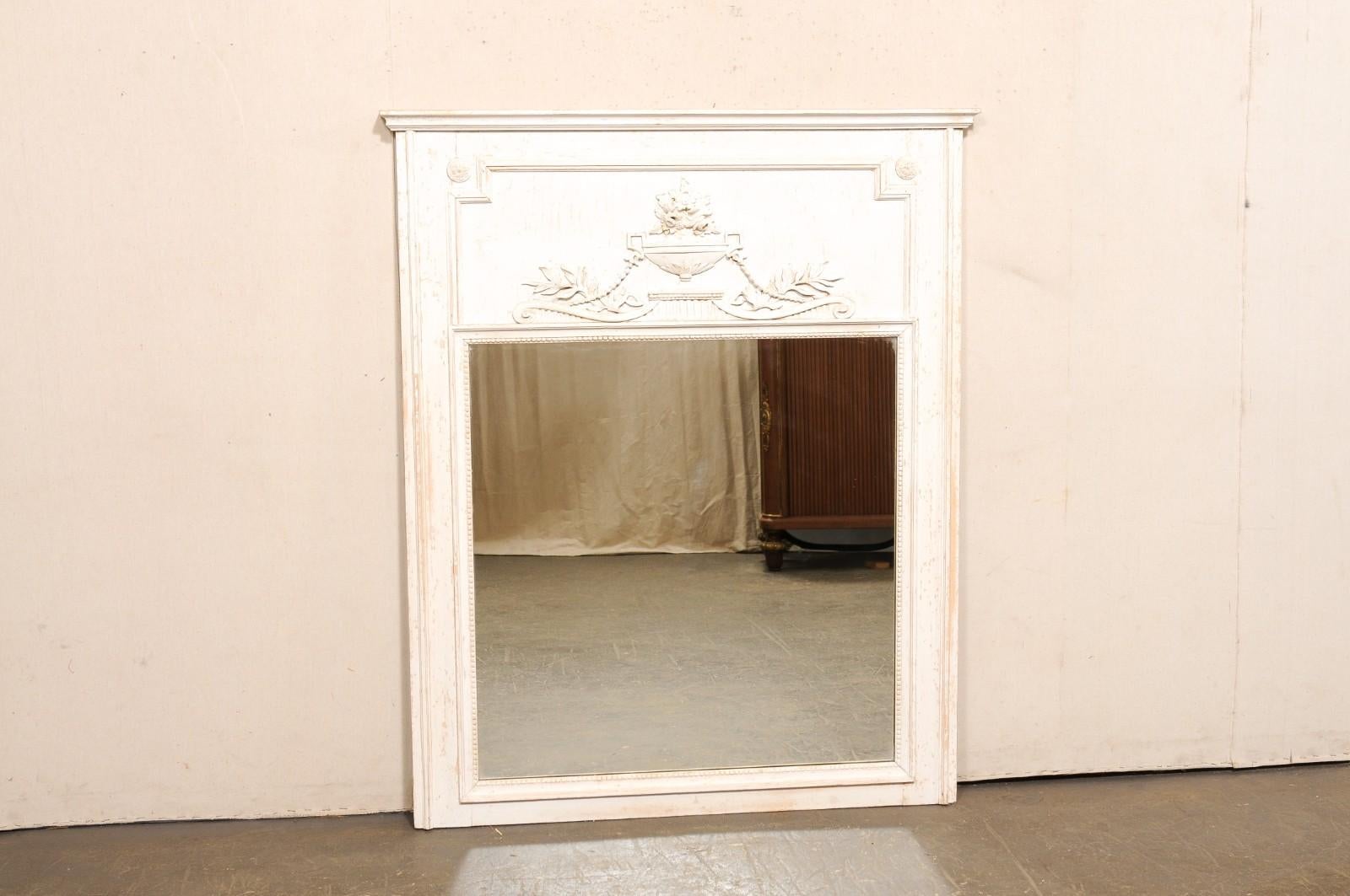 Miroir trumeau en bois peint de style néoclassique français du début du 20e siècle. Ce miroir ancien de France présente une plaque supérieure en bois sculpté, typique du design trumeau, avec une moulure linéaire sur la traverse supérieure, et une