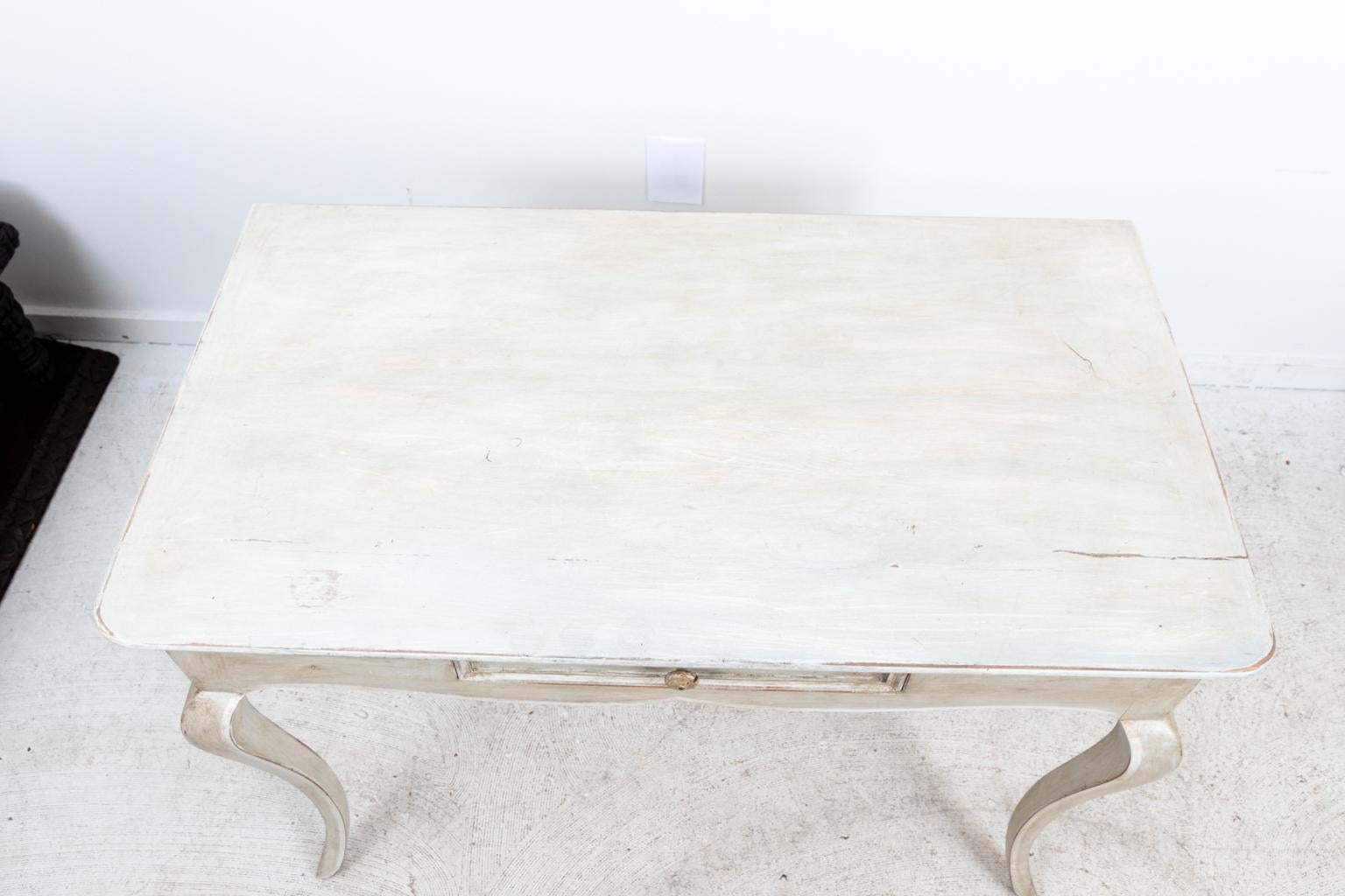 Circa 1920s French Louis XV style antique painted console in a cream color with white accents. The piece also features a single drawer. Purchased at Marche Au Pures. Made in France. Please note of wear consistent with age, the drawer catches lightly