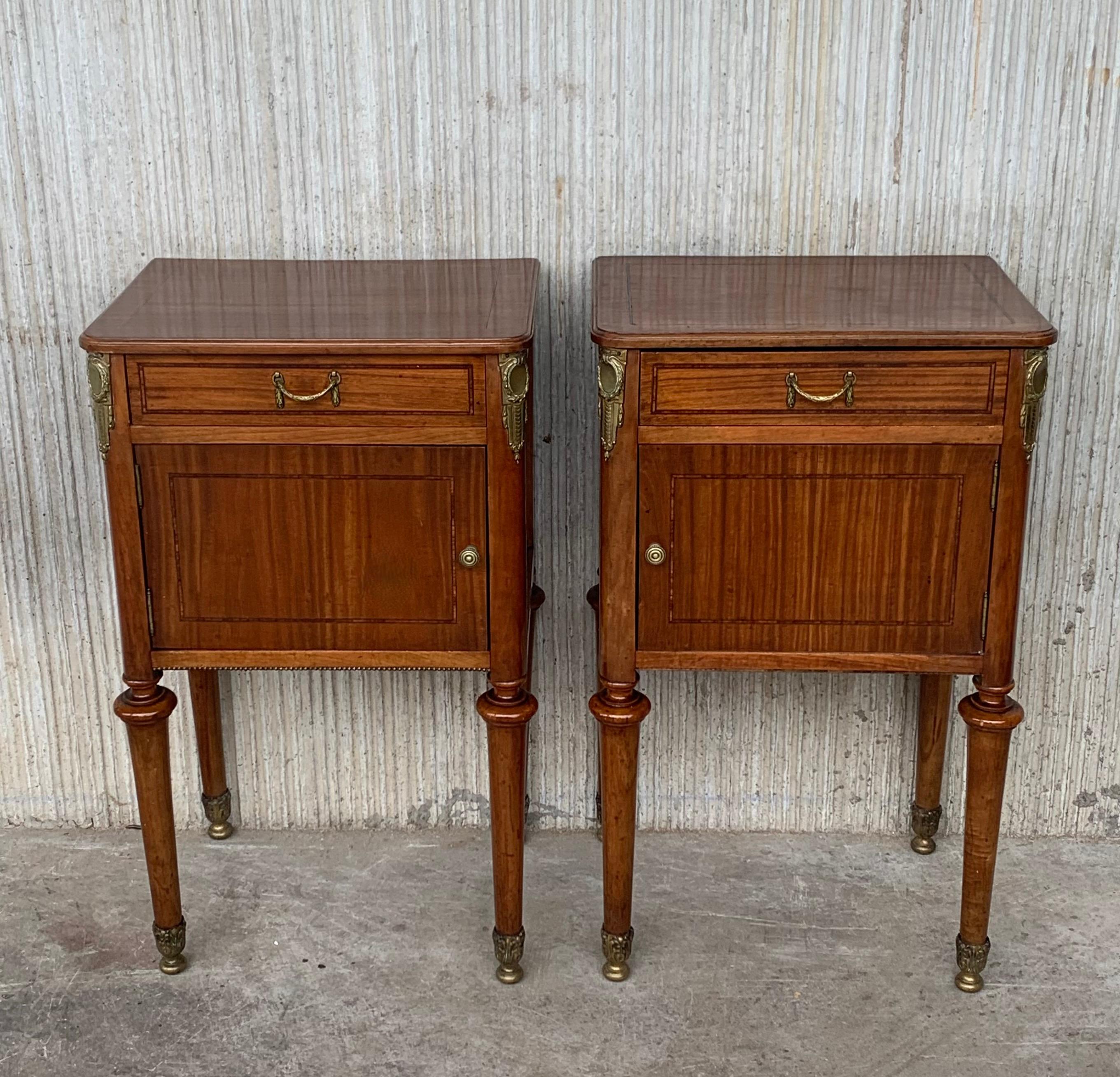 This is a French antique bedside cabinet dating to the late 19th century, circa 1890. Appealing biscuit tones to the light walnut finish Attractive grain in the quartered veneered decoration. Raised on round, tapering walnut legs, pinched beneath