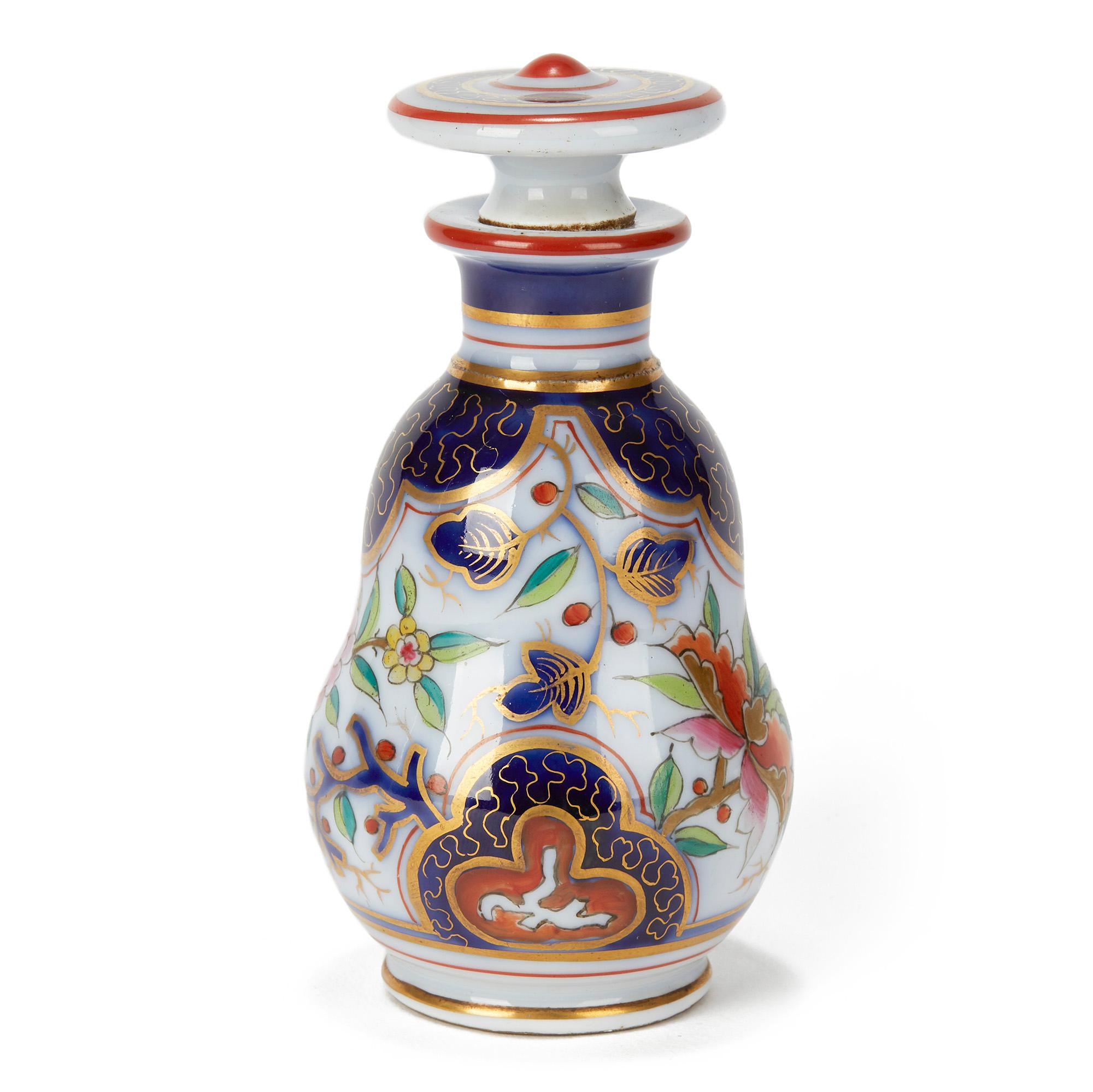 Un très beau flacon de parfum et un bouchon en porcelaine française, richement décorés dans la palette Imari sur un fond teinté bleu et rehaussé de dorures. Le flacon de parfum n'est pas marqué mais conserve une ancienne étiquette de papier de