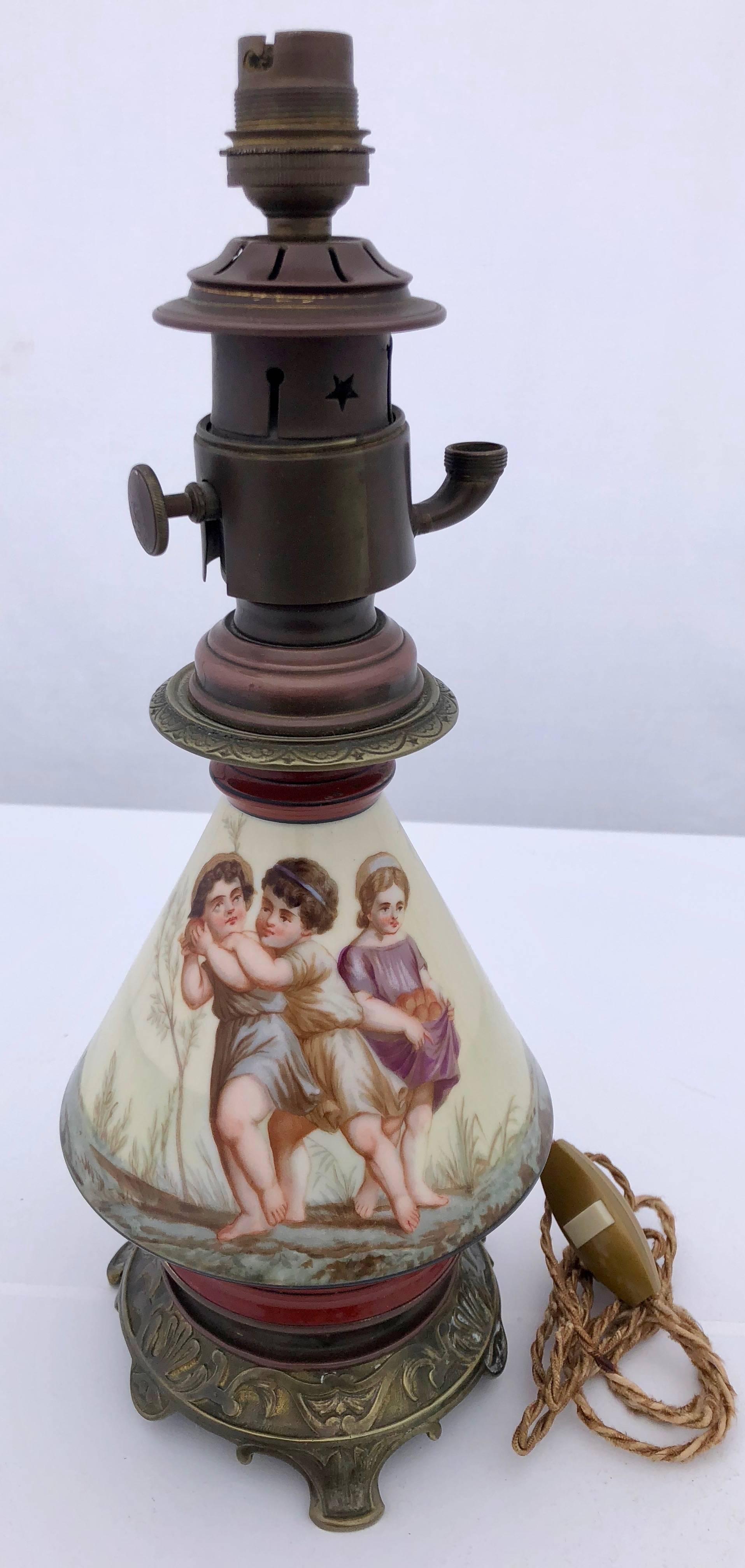 This is a gorgeous lamp with two different hand-painted scenes of children picking fruit. The colors are vibrant and the painted children's faces are exquisite. The lamp stand is metal in an antique brass color and the lamp hardware is metal in a