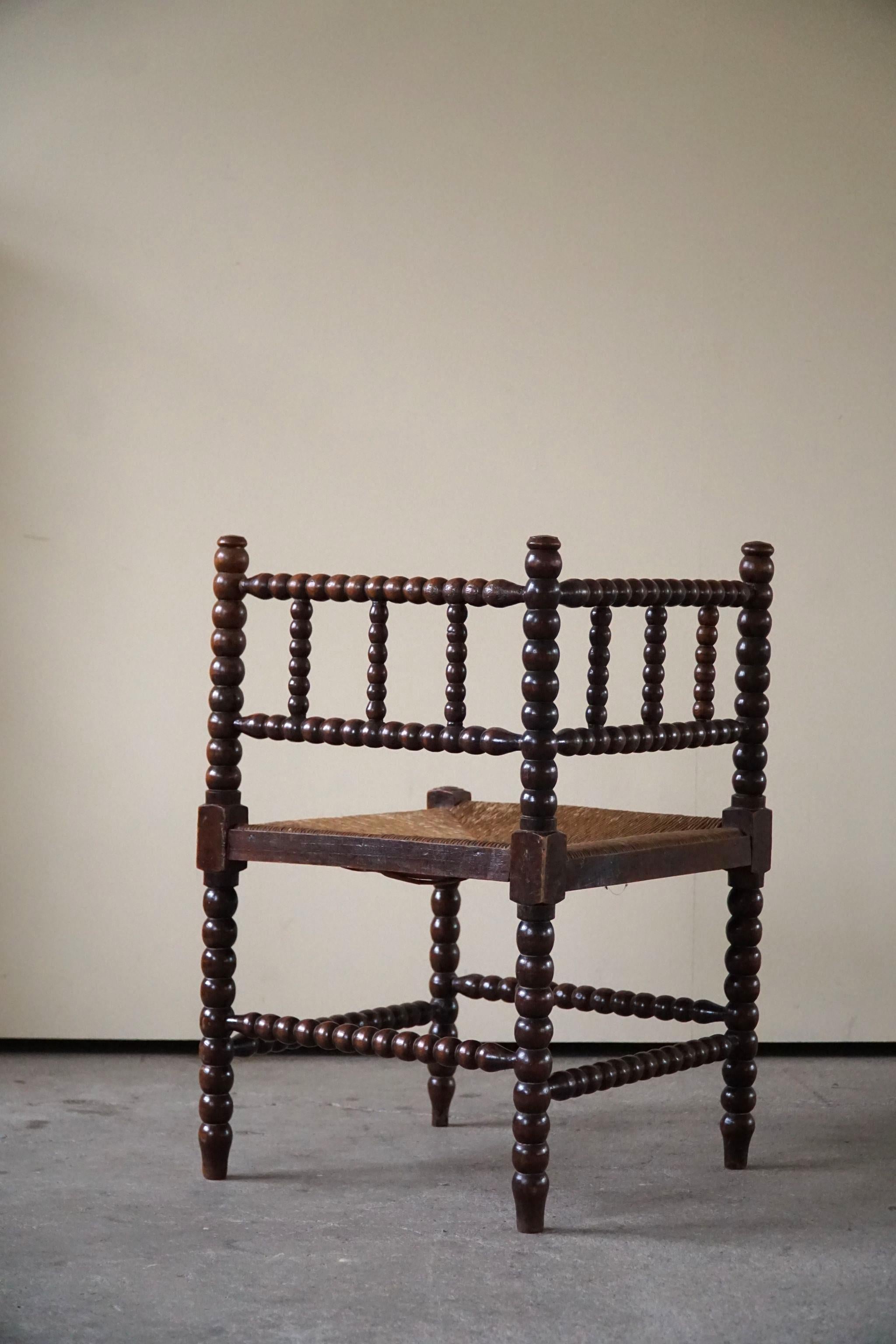 A fine French Provincial corner chair in stained beech with a handwoven seagrass seat. Classic bobbin turned legs and in a overall fine vintage condition. Made in the 19th century.

Lovely handmade chair that will complement many interior styles.