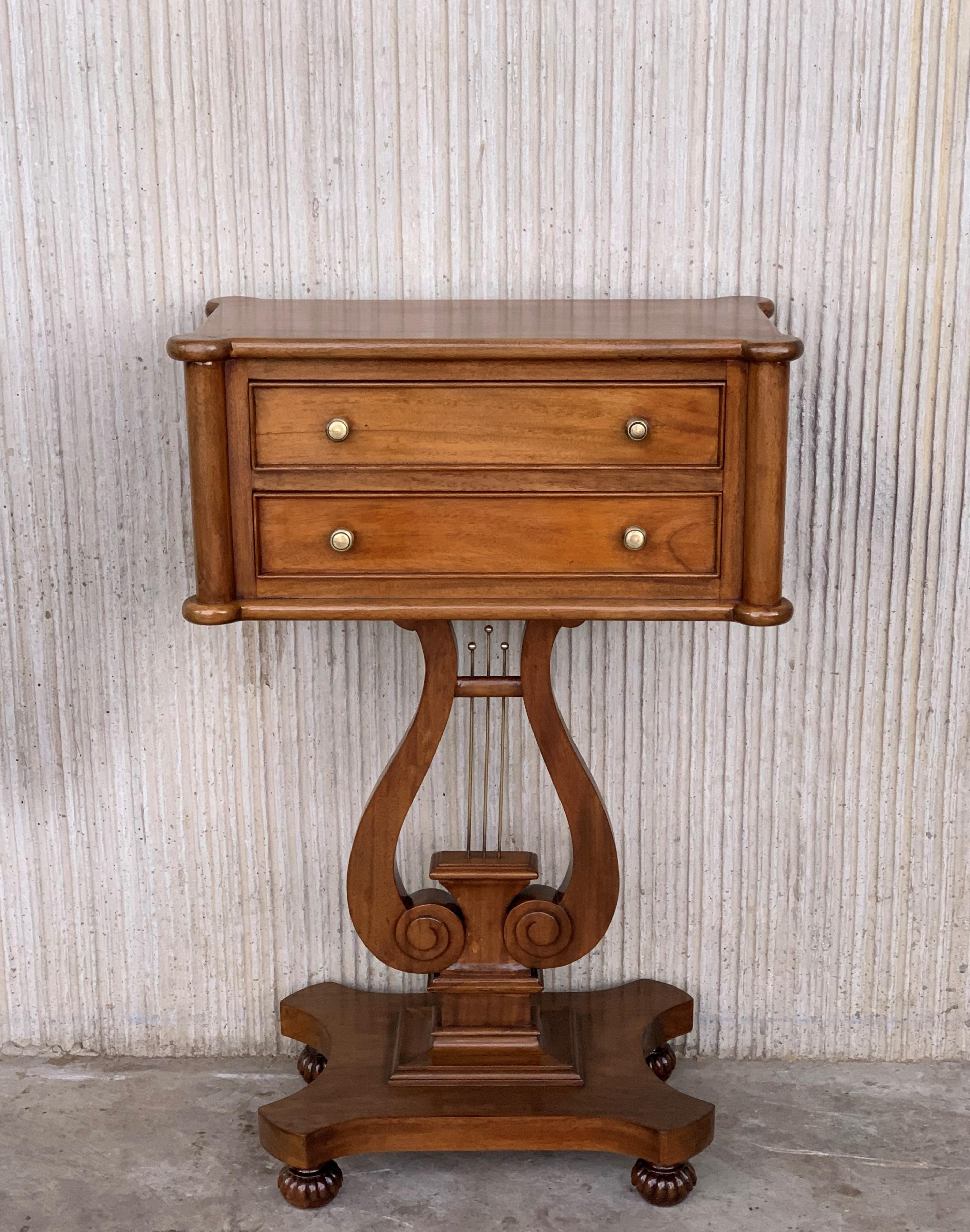 A smart and top quality antique side table in walnut, is made in the antique Regency style, they date from circa 1930s-1950s.

The top have beautiful form on solid wood, with crossbanded edges. They sit on two drawers and lovely harp shaped leg