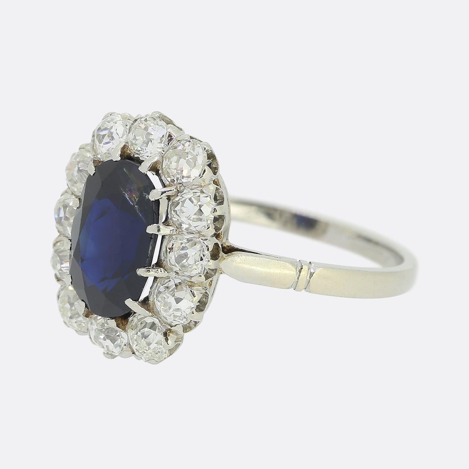Hier haben wir einen fabelhaften antiken Saphir- und Diamant-Cluster-Ring. Dieses in Frankreich zu Beginn des 20. Jahrhunderts aus Platin gefertigte Stück zeigt in der Mitte des Zifferblatts einen ovalen Saphir in einem satten königsblauen Farbton.