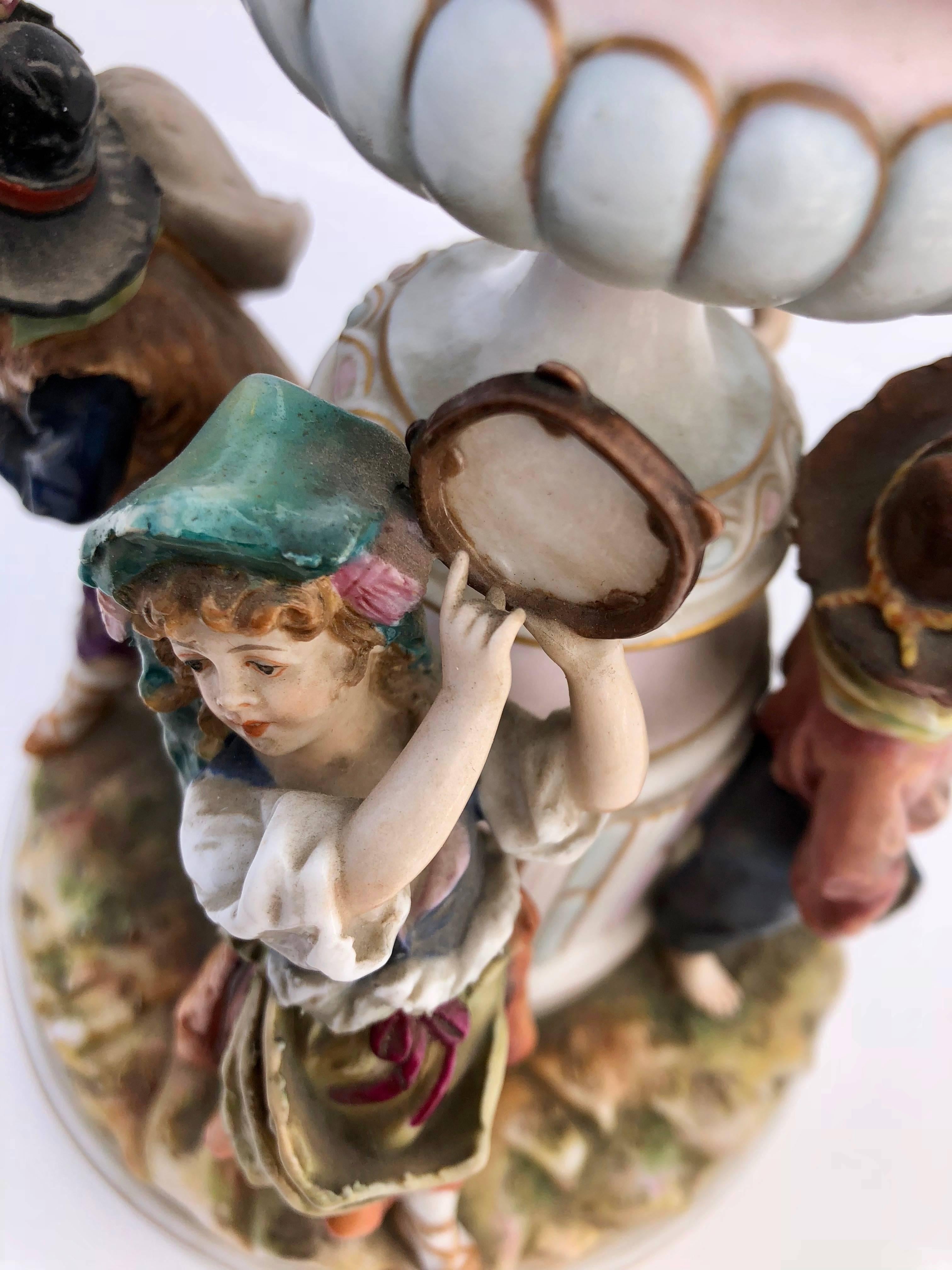 This beautiful antique French Saxe porcelain figurine includes a group of four adorable children in varying country poses. It has a variety of paint colors with a glossy finish and is simply gorgeous.