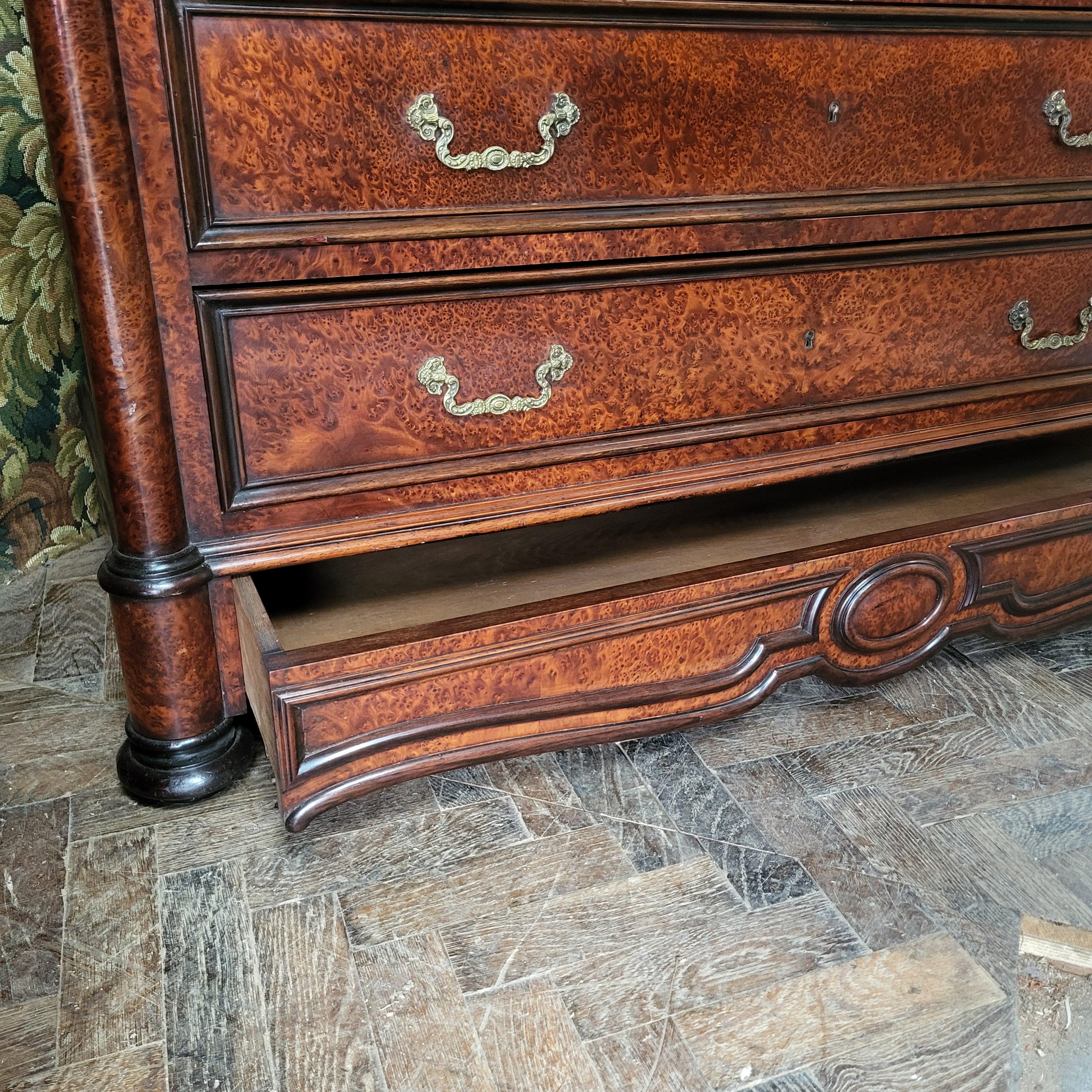 This French antique secretaire commode, offered by Hutton-Clarke Antiques, features a stunning exterior of burr yew with contrasting rosewood mouldings, topped with an original Carrera marble top with moulded corners. The front opens to reveal a