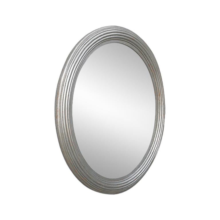 Antique oval silver mirror with grooved decor. Re-gilding to the patinated leaf. Antique laminated wood back. Dimensions: 73.5 cm H x 63.5 cm W. Modern glass mirror. Antique frame width: 7 cm.