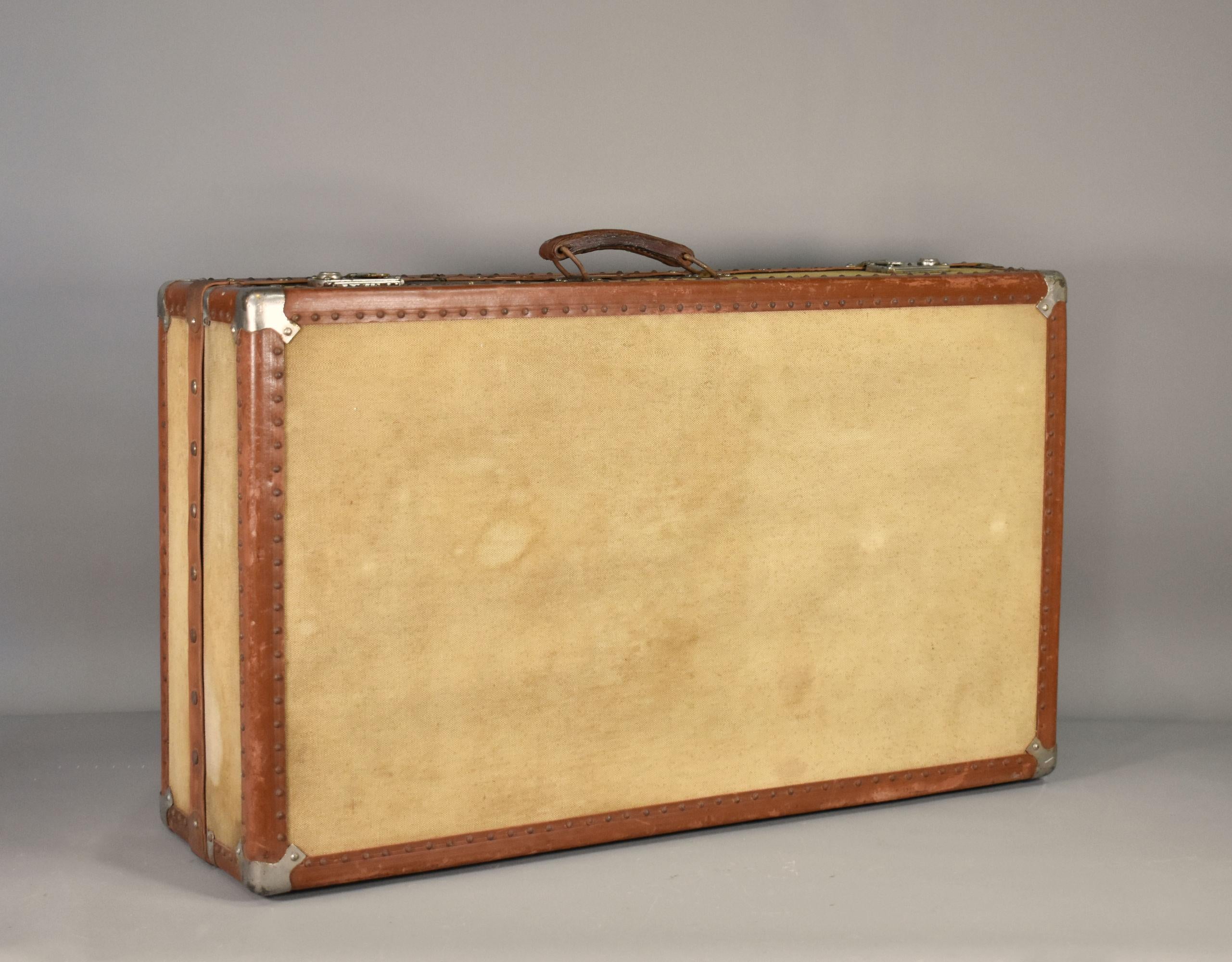 French Antique Steamer Trunk Suitcase 

A sturdy Steamer Trunk / Travelling Suitcase that features reinforced corner brackets and leather-bound edges. 

It is covered in a light cream canvas on all sides. 

On top are two working catches, a