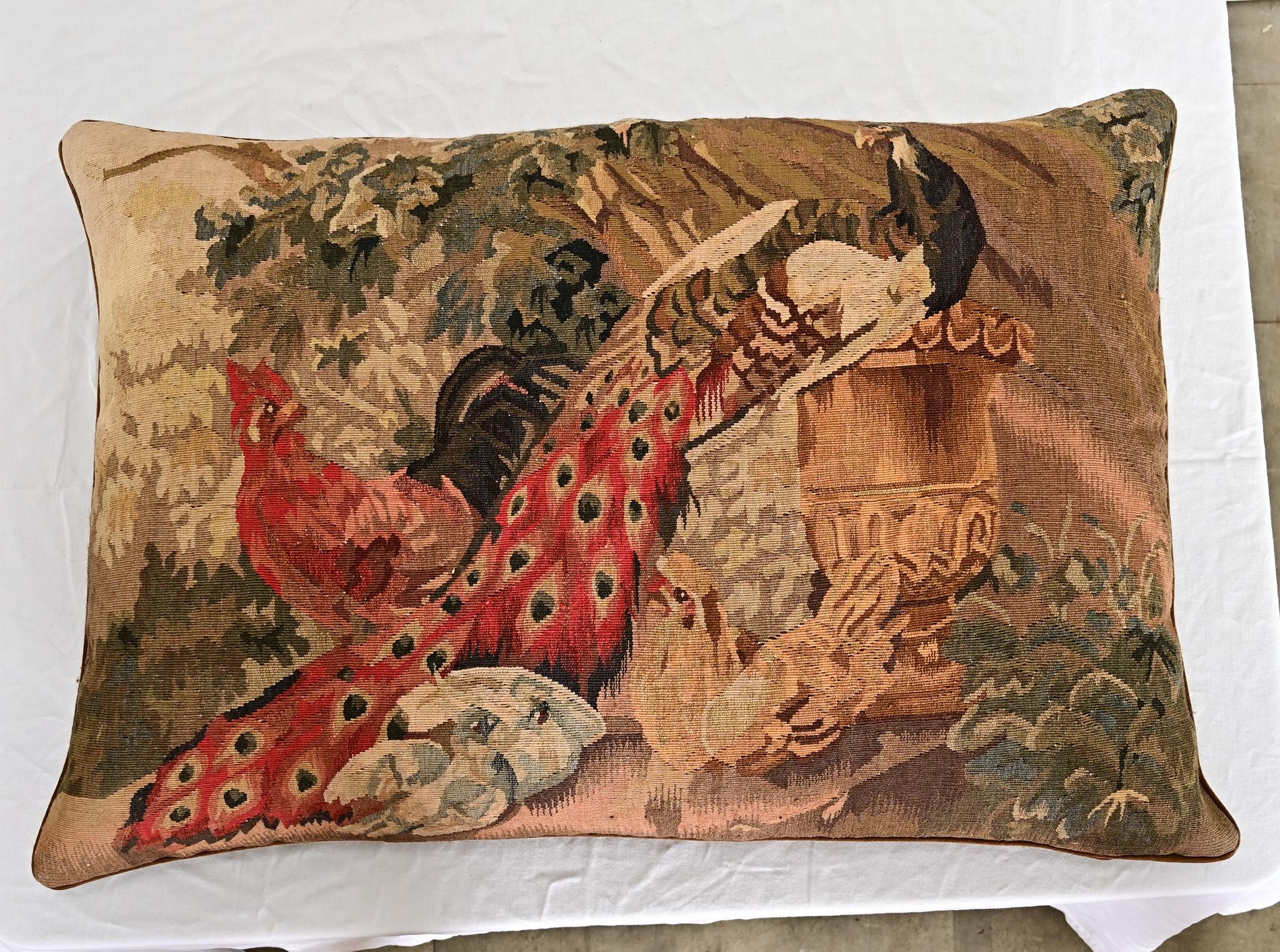 A recently made custom cushion (or large pillow) from an antique tapestry fragment of the Aubusson-Verdure tradition dating to 19th century France, depicting a peacock atop a traditional garden urn while a rooster and chicken observe the scene from